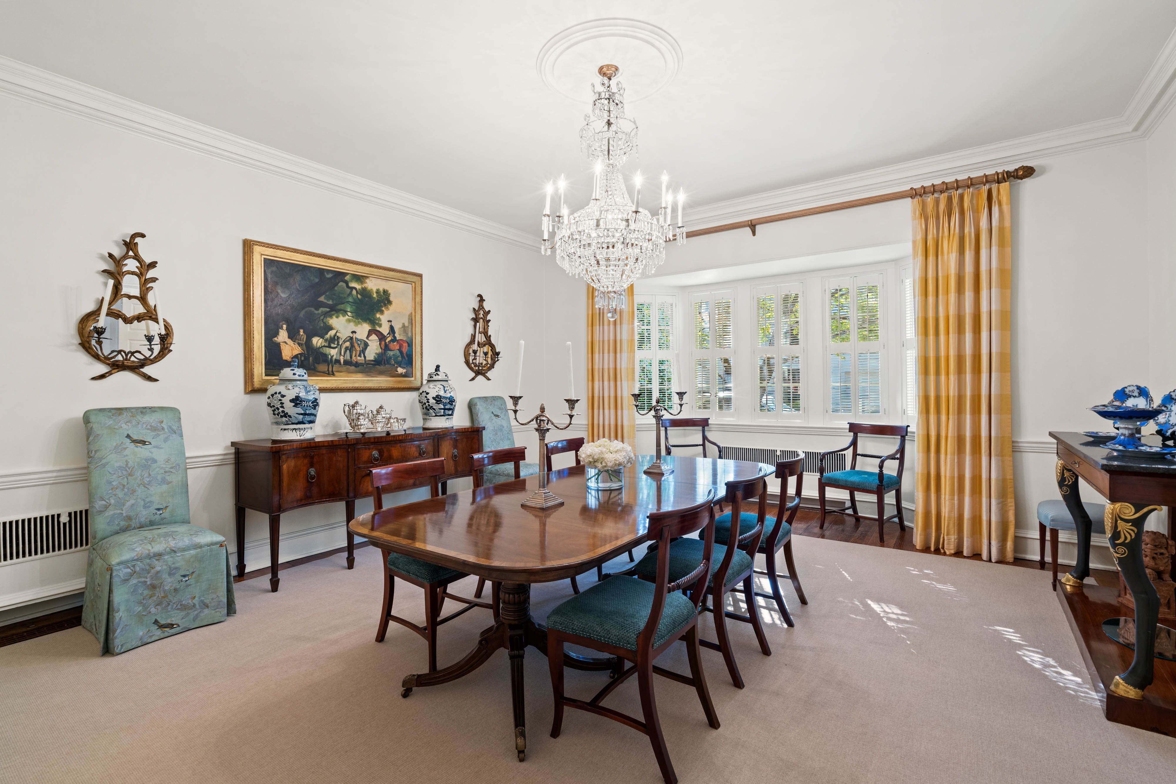 A photo of a dining room with a large dining table and chairs.