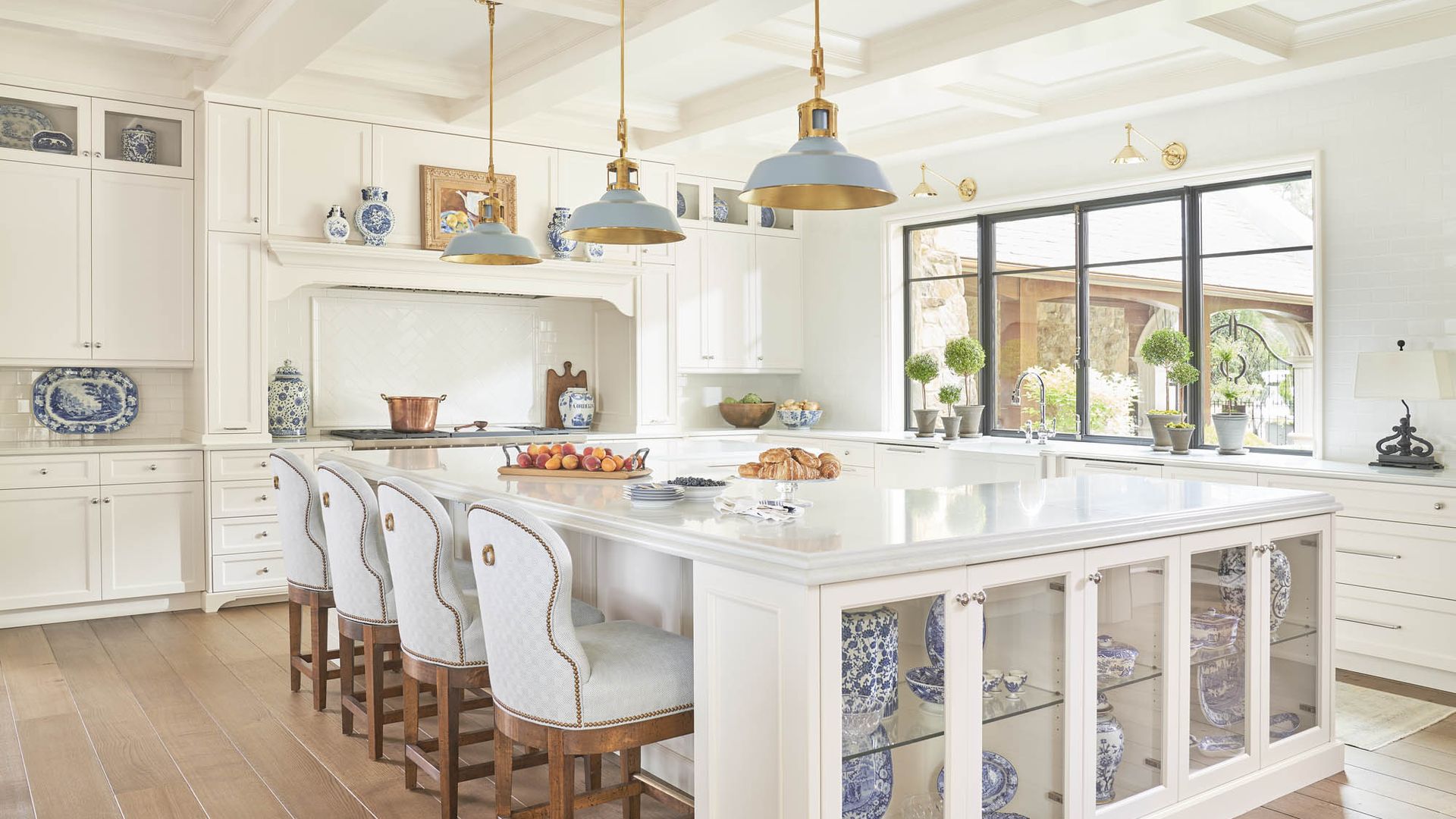 luxury kitchen with a u-shaped island and blue and white ginger jars spread around
