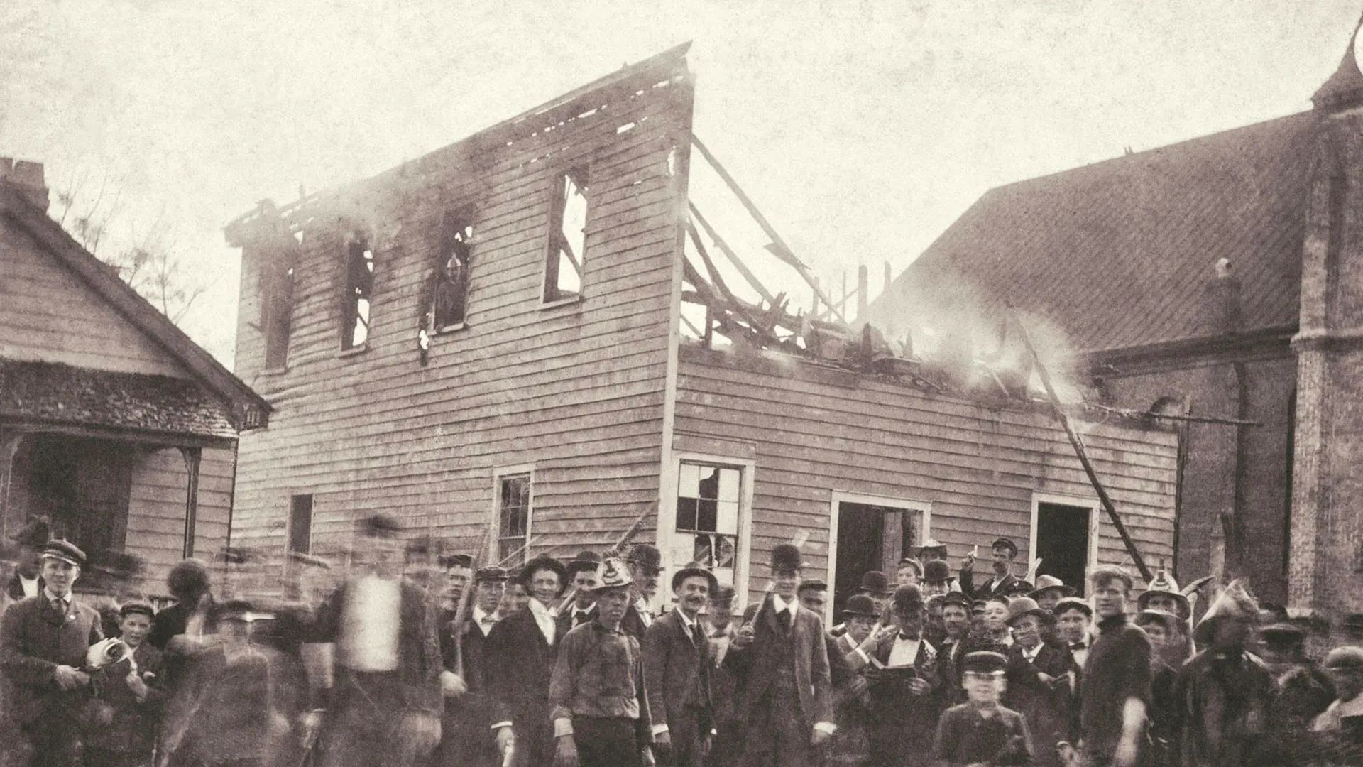 A mob stands outside of the burned offices of The Daily Record, Wilmington's Black-owned newspaper in Nov. 1898. Photo: New Hanover County Public Library