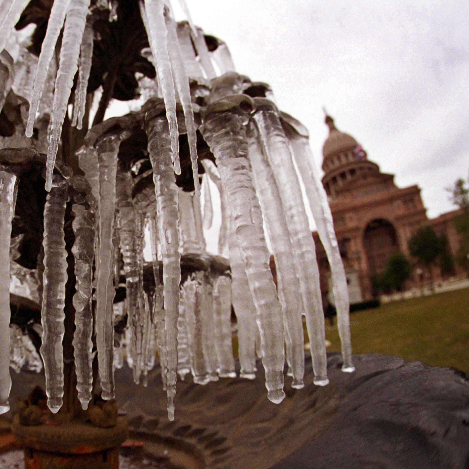Icicles hang from a frozen water fountain in front of the state Capitol building in Austin.