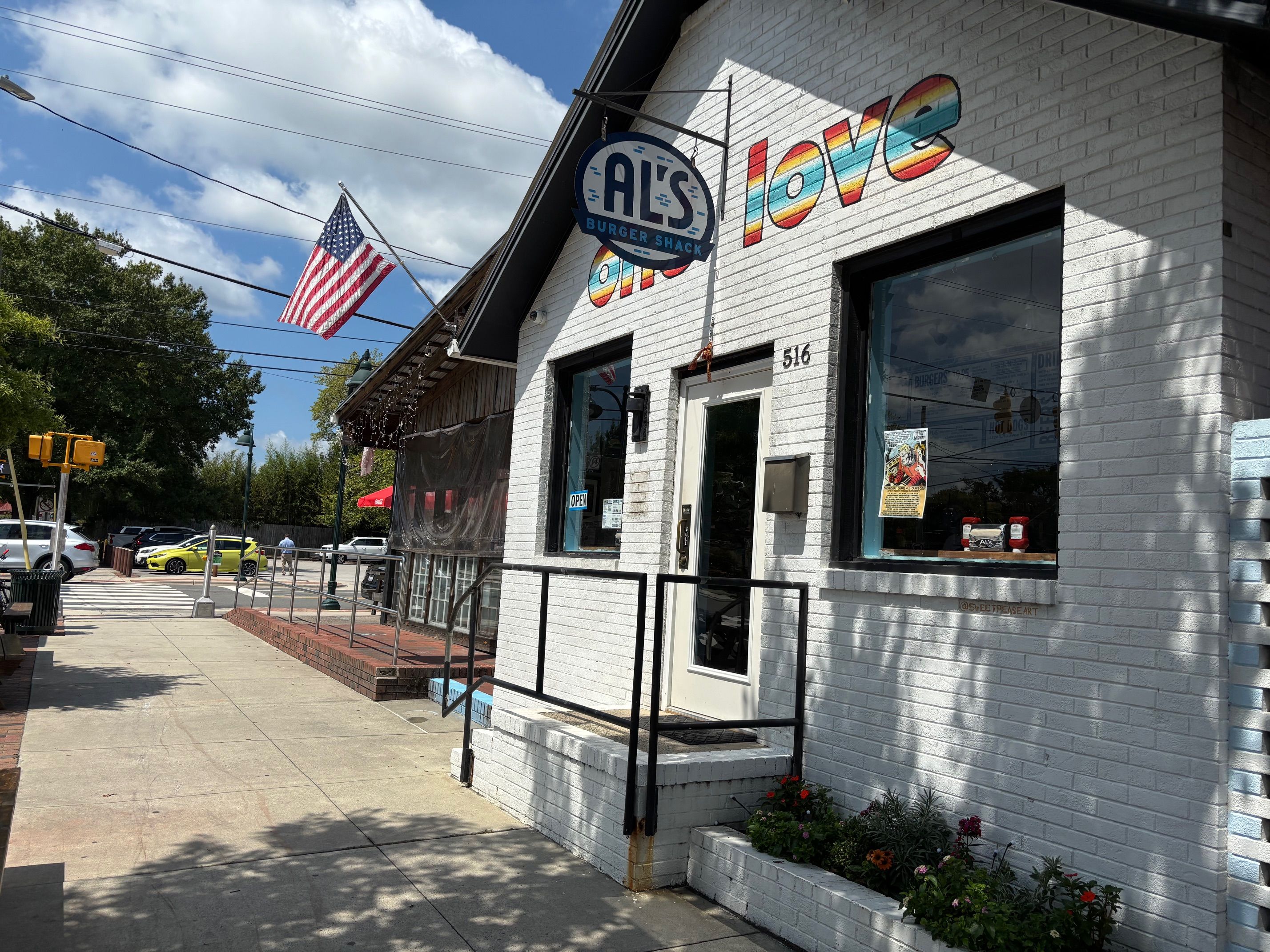 White brick building with rainbow-striped word \