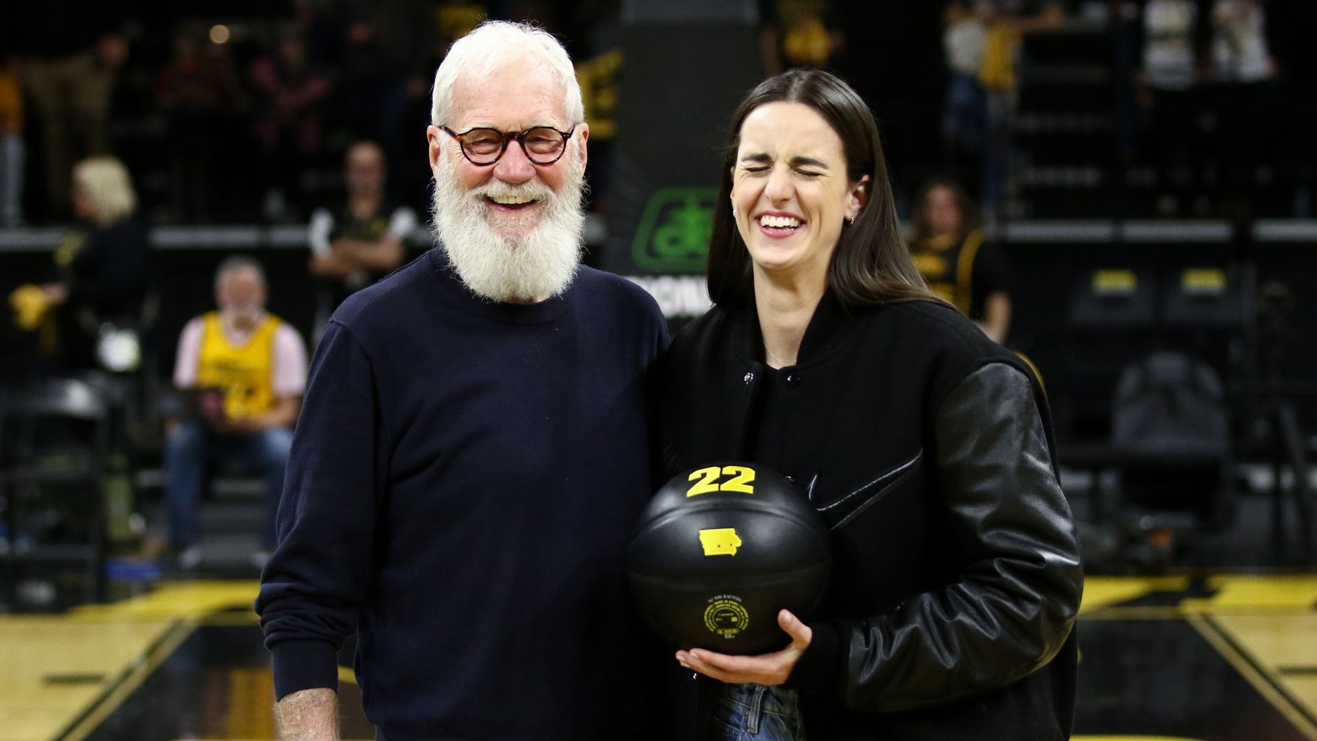 Former Iowa Hawkeye guard and current Indiana Fever guard Caitlin Clark #22 poses with comedian David Letterman during a ceremony to retire her #22 jersey following the match-up against the USC Trojans, at Carver-Hawkeye Arena on February 2, 2025 in Iowa City, Iowa.