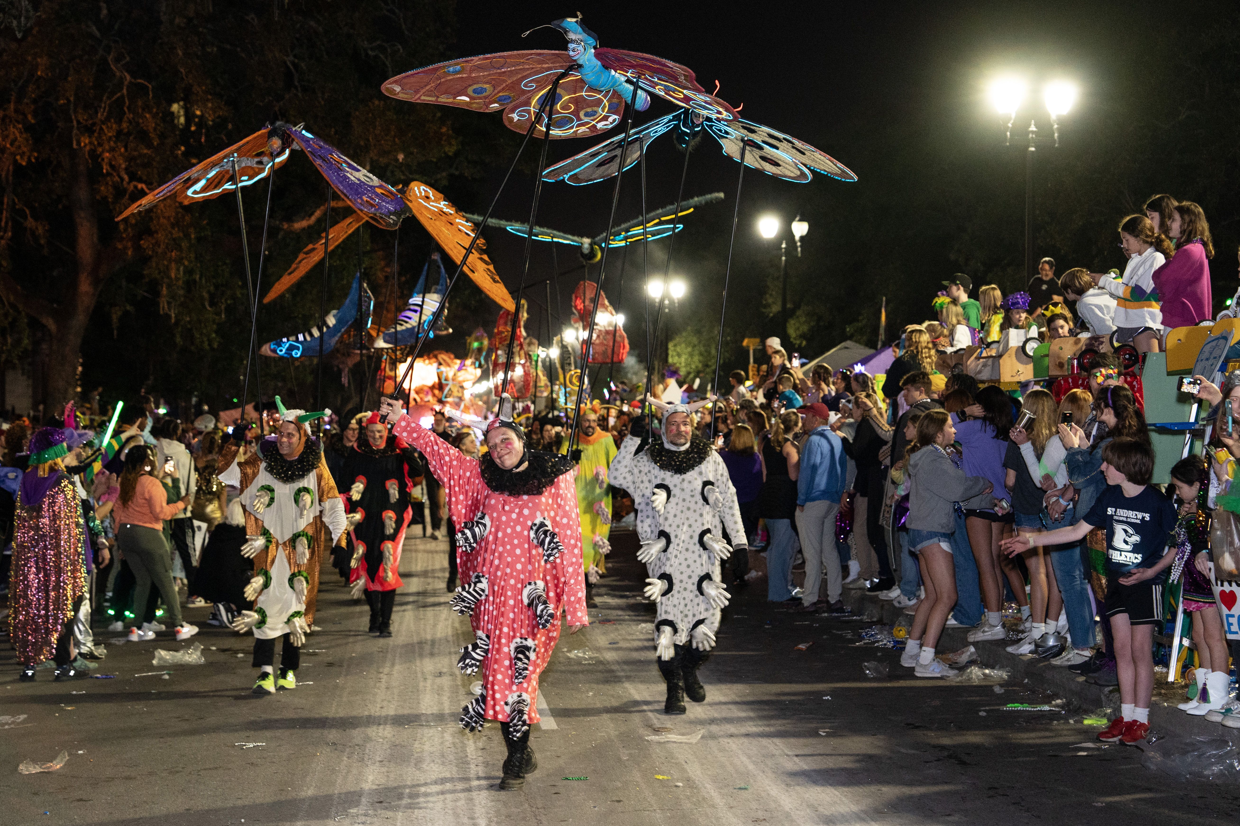 Photo shows walking group with butterfly puppets in the Krewe of Muses parade
