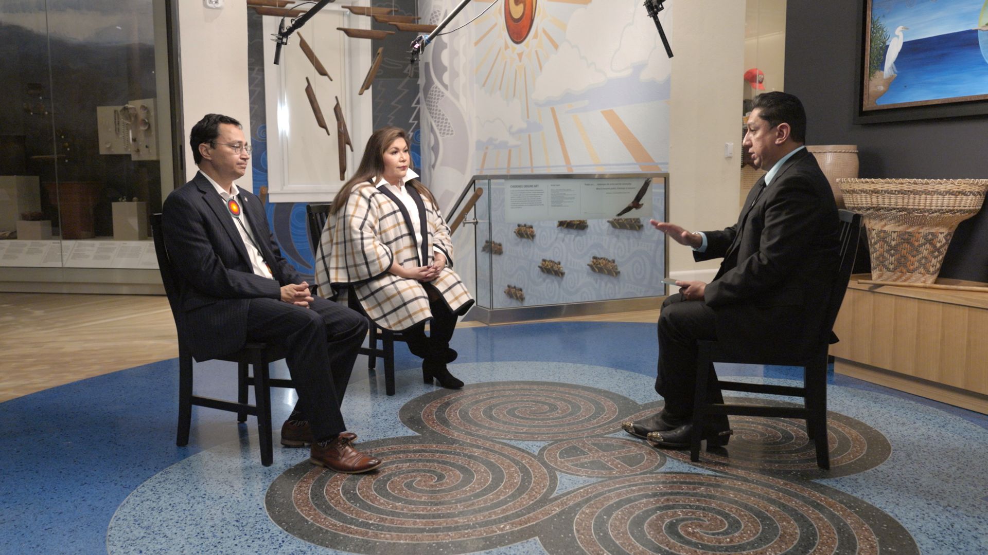Axios' Russell Contreras is seen speaking with Cherokee principal chief Chuck Hoskin Jr. and delegate-elect Kim Teehee.