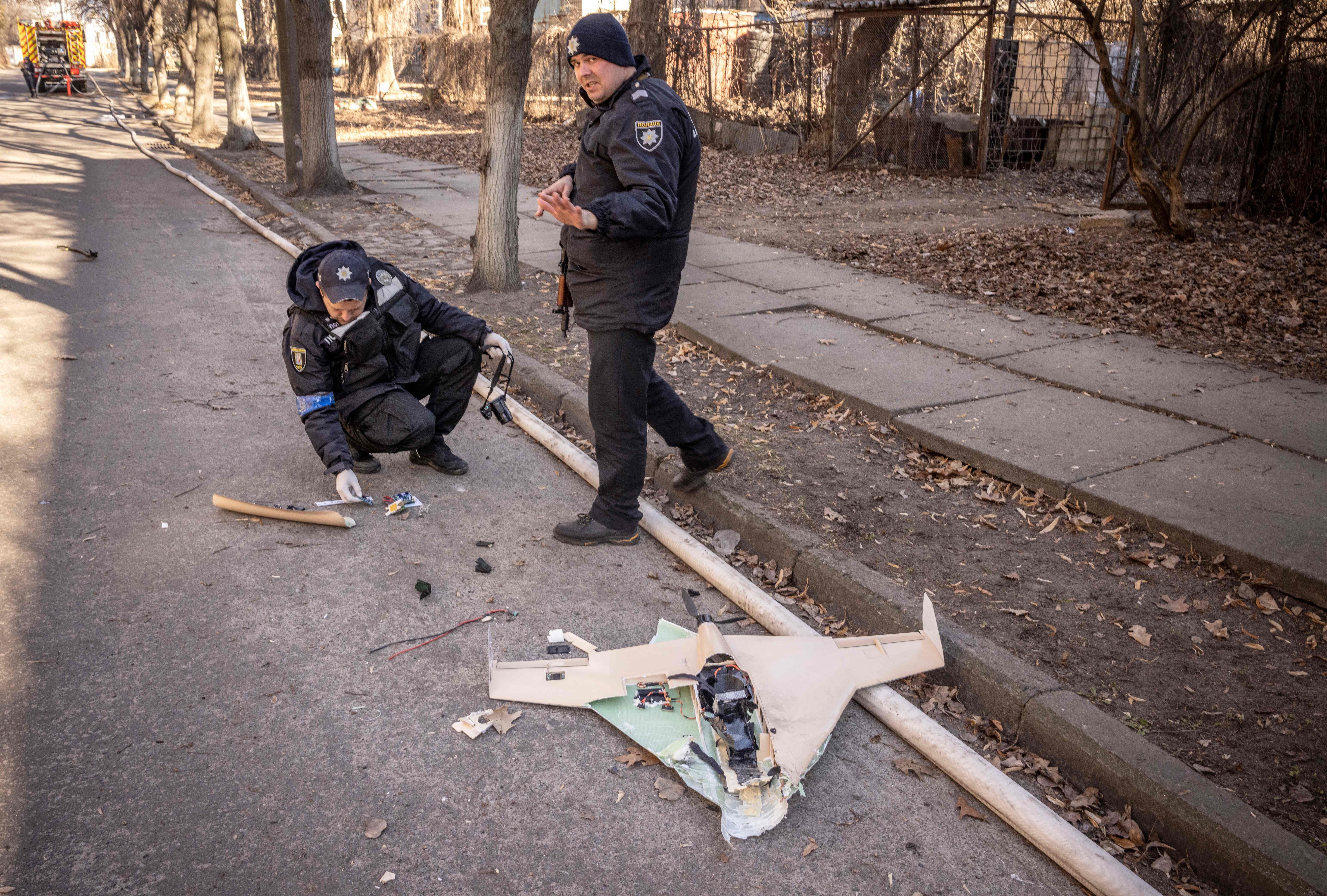 Ukrainian police officers inspect a downed Russian drone in the area of a research institute, part of Ukraine's National Academy of Science, after a strike, in northwestern Kyiv, on March 22.