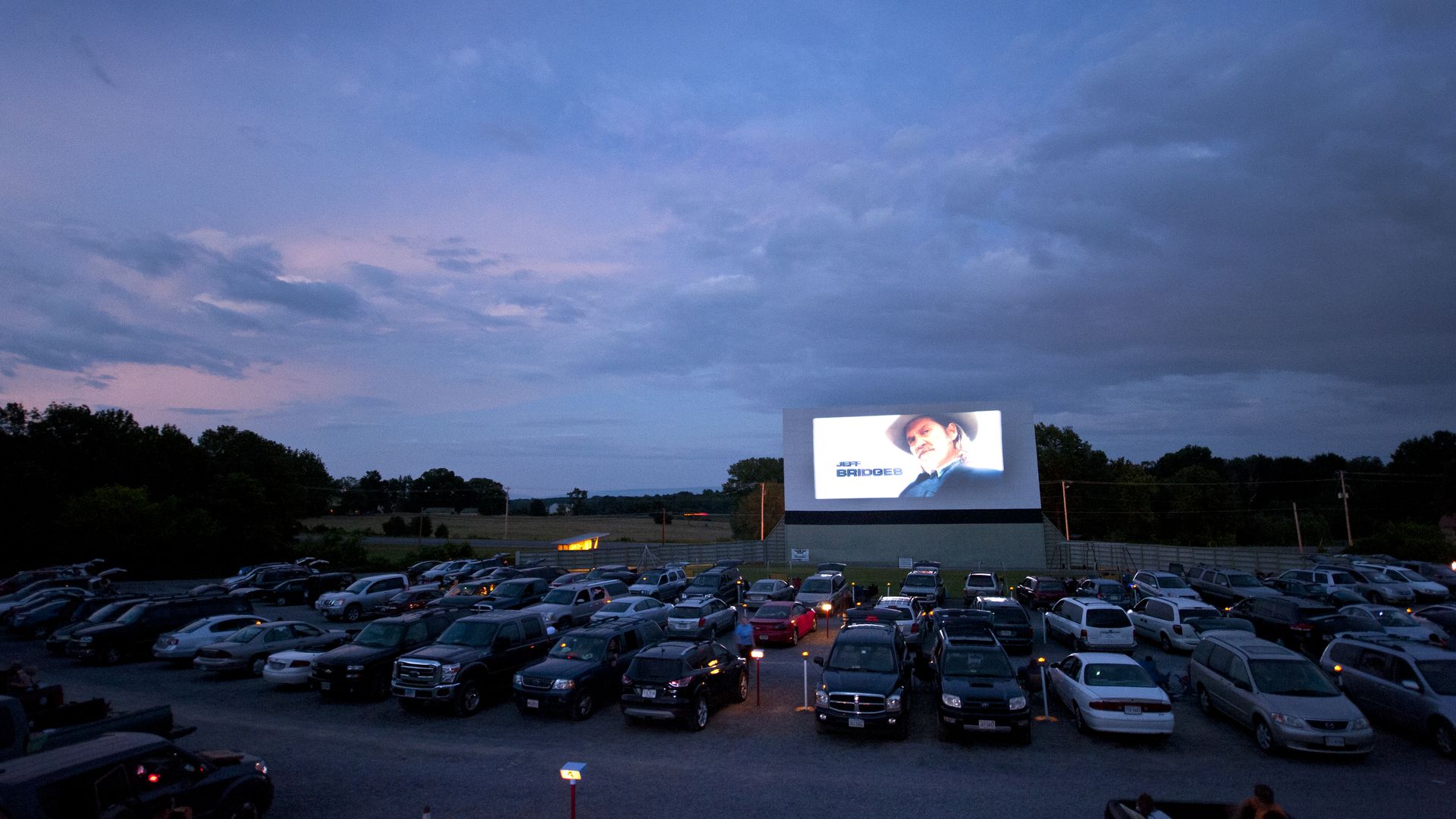 Image of a drive-in movie theater at twilight.