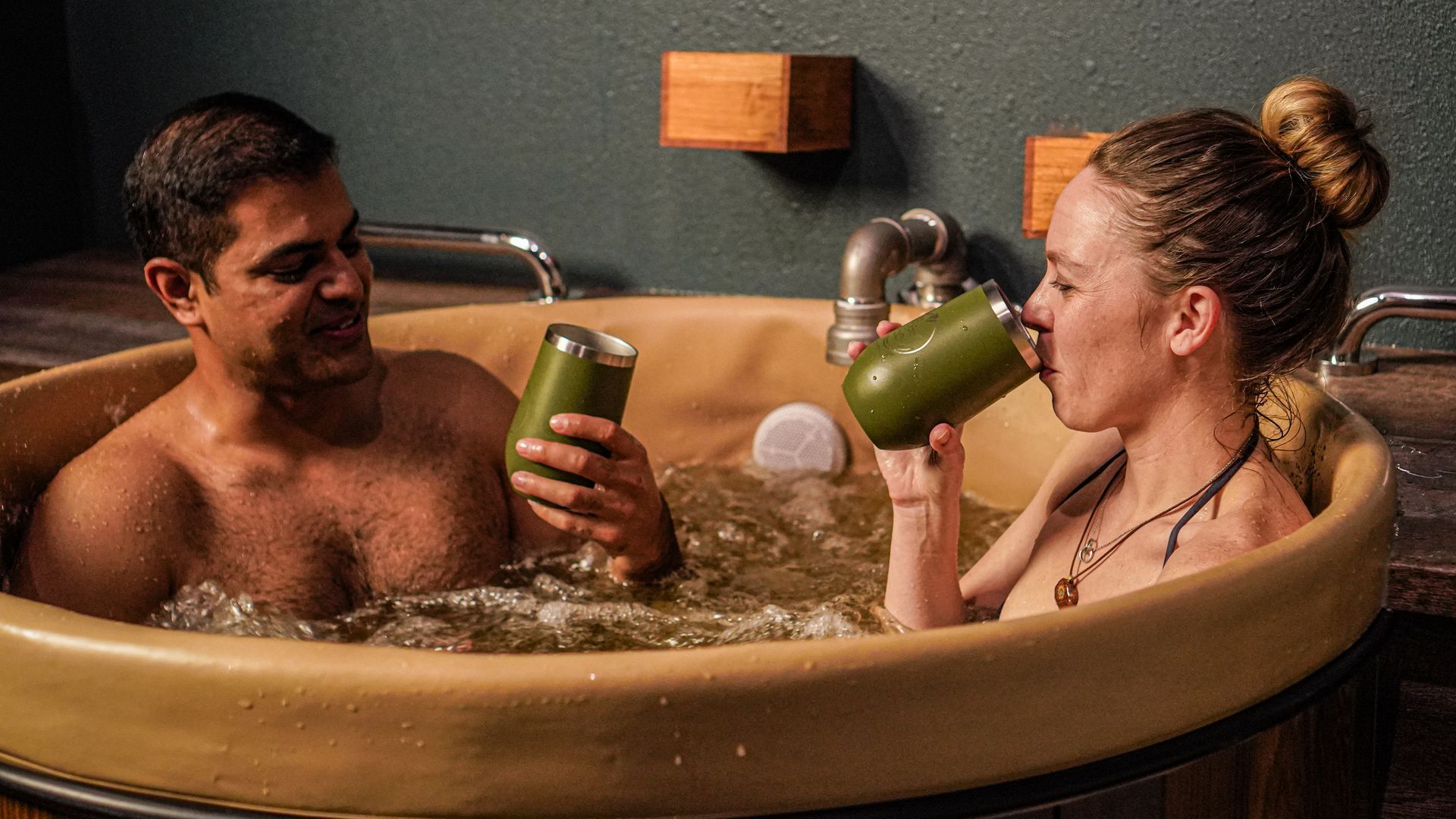 Picture of two people in a bath tub filled with water that smells similar to beer