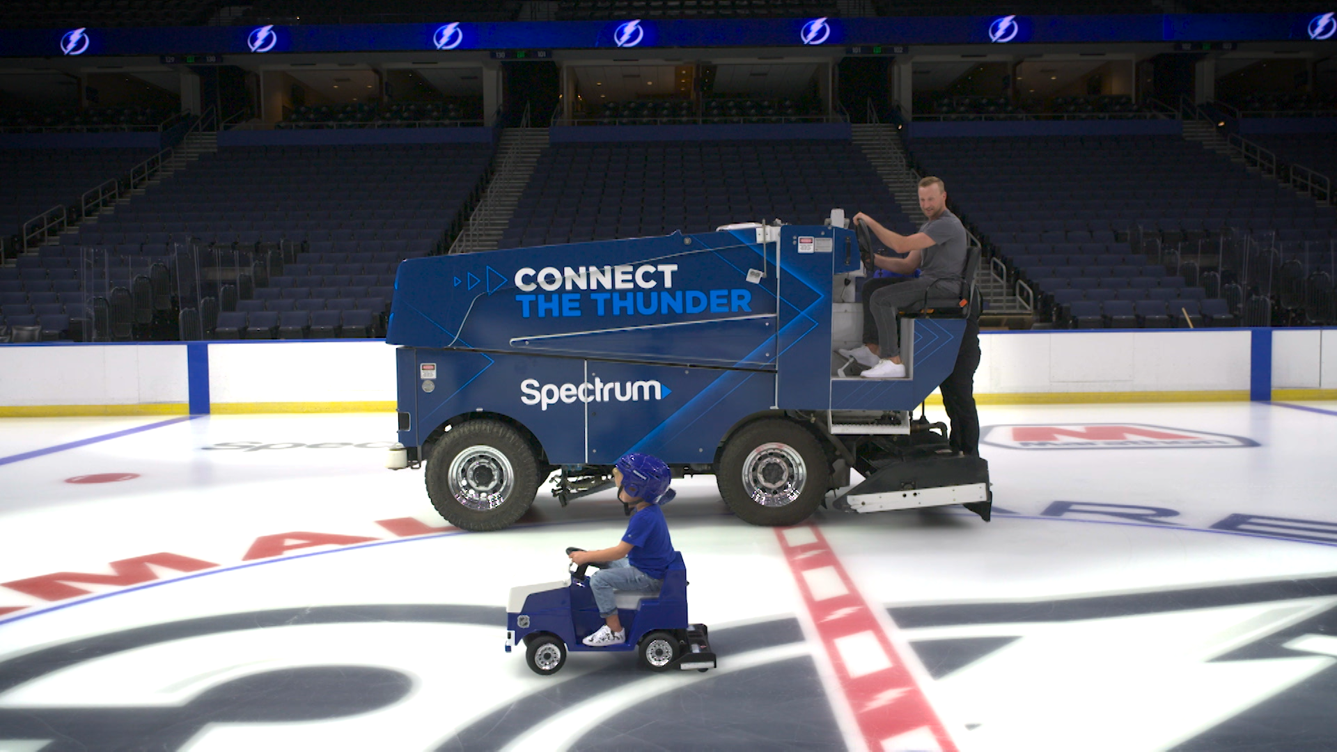 Steve Stamkos rides a Zamboni at Amalie Arena while his son, Carter, rides his own mini Zamboni