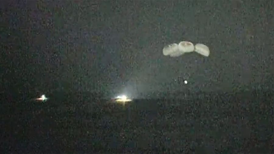 A night-vision camera pictures the SpaceX Crew Dragon parachuting to splashdown in the Gulf of Mexico as fast boats arrive to retrieve the crew. 