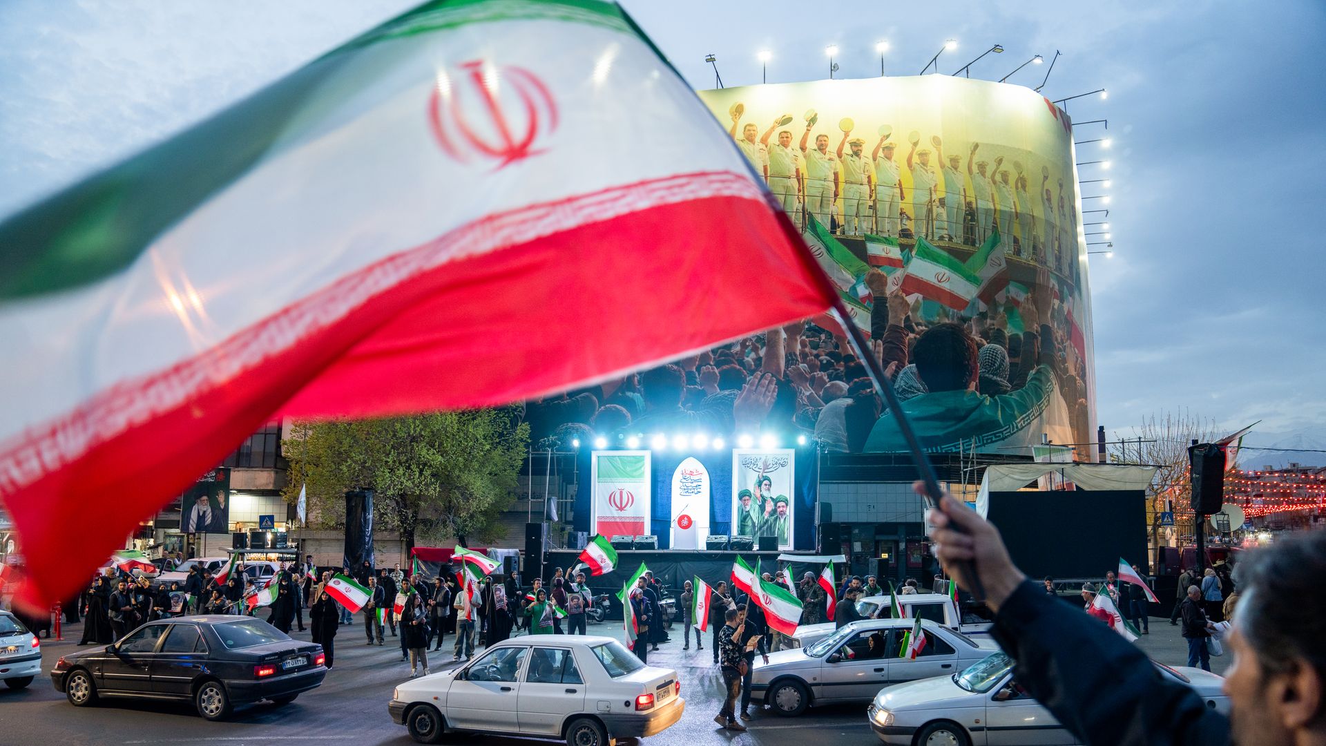 Crowd in central Tehran waving Iranian flags during a pro-government rally amid the 2026 Iran war.