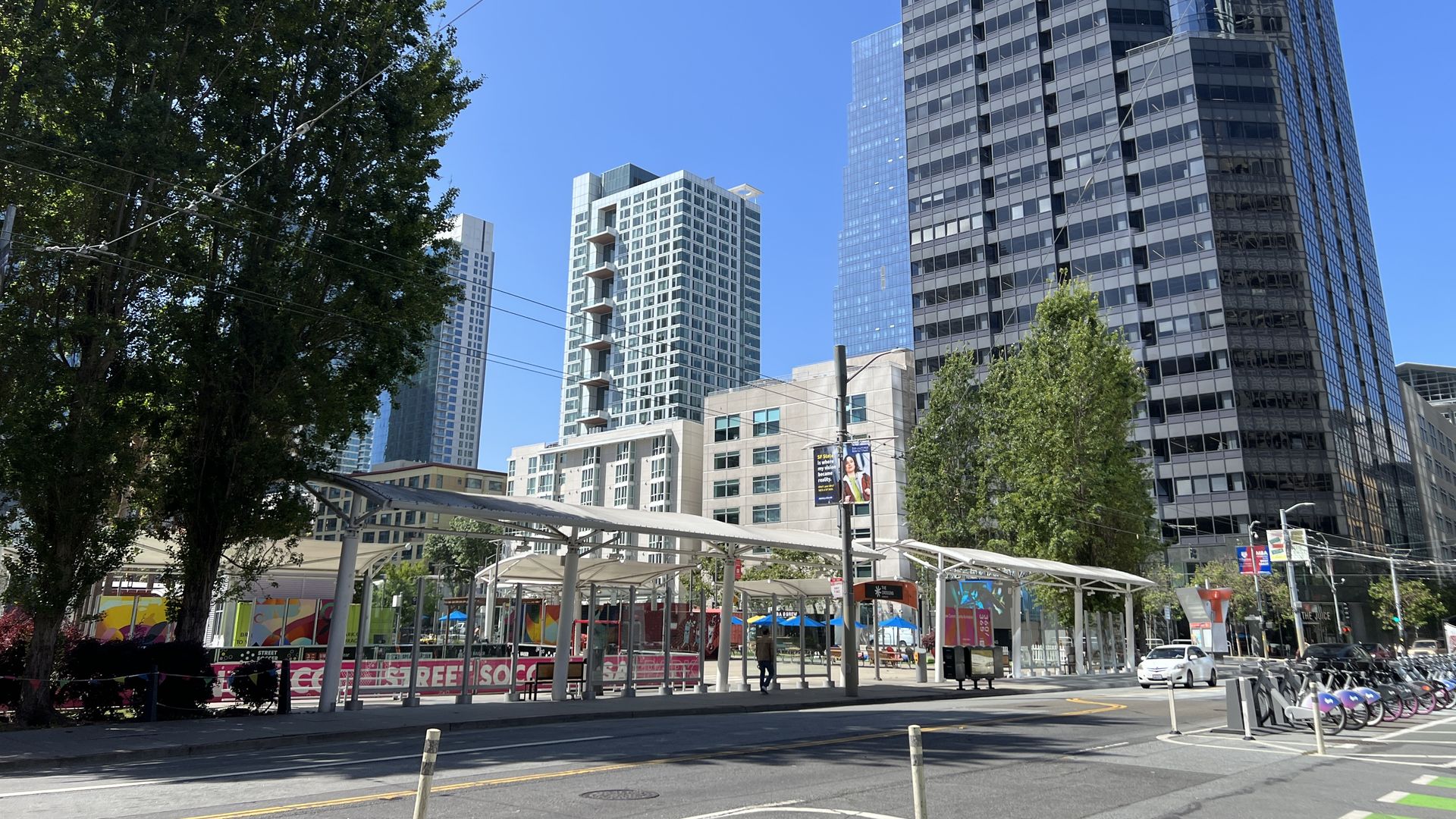 Photo of a street next to high-rise buildings and a bus station