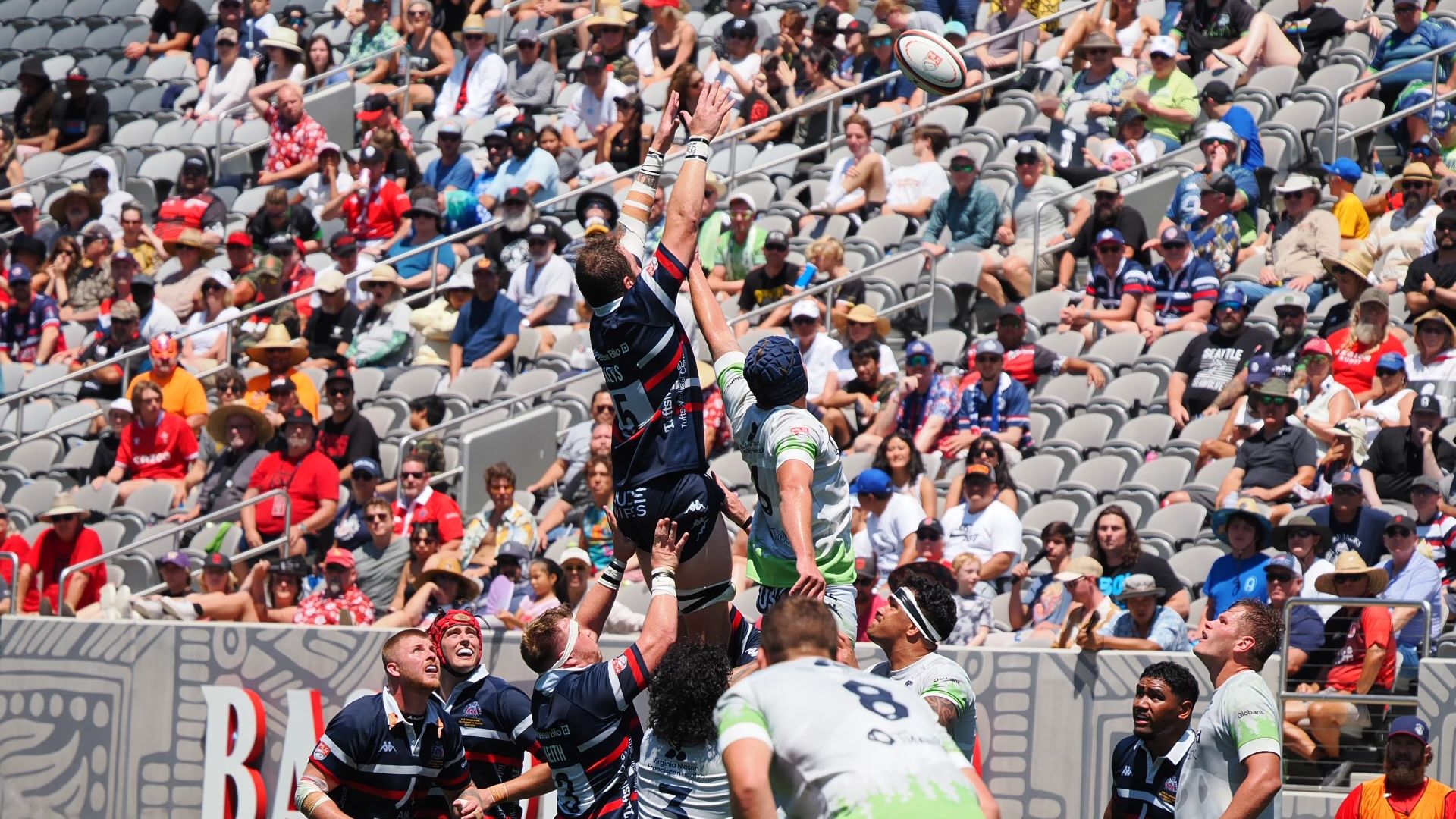 Rugby players lift teammates in the air during a match. 