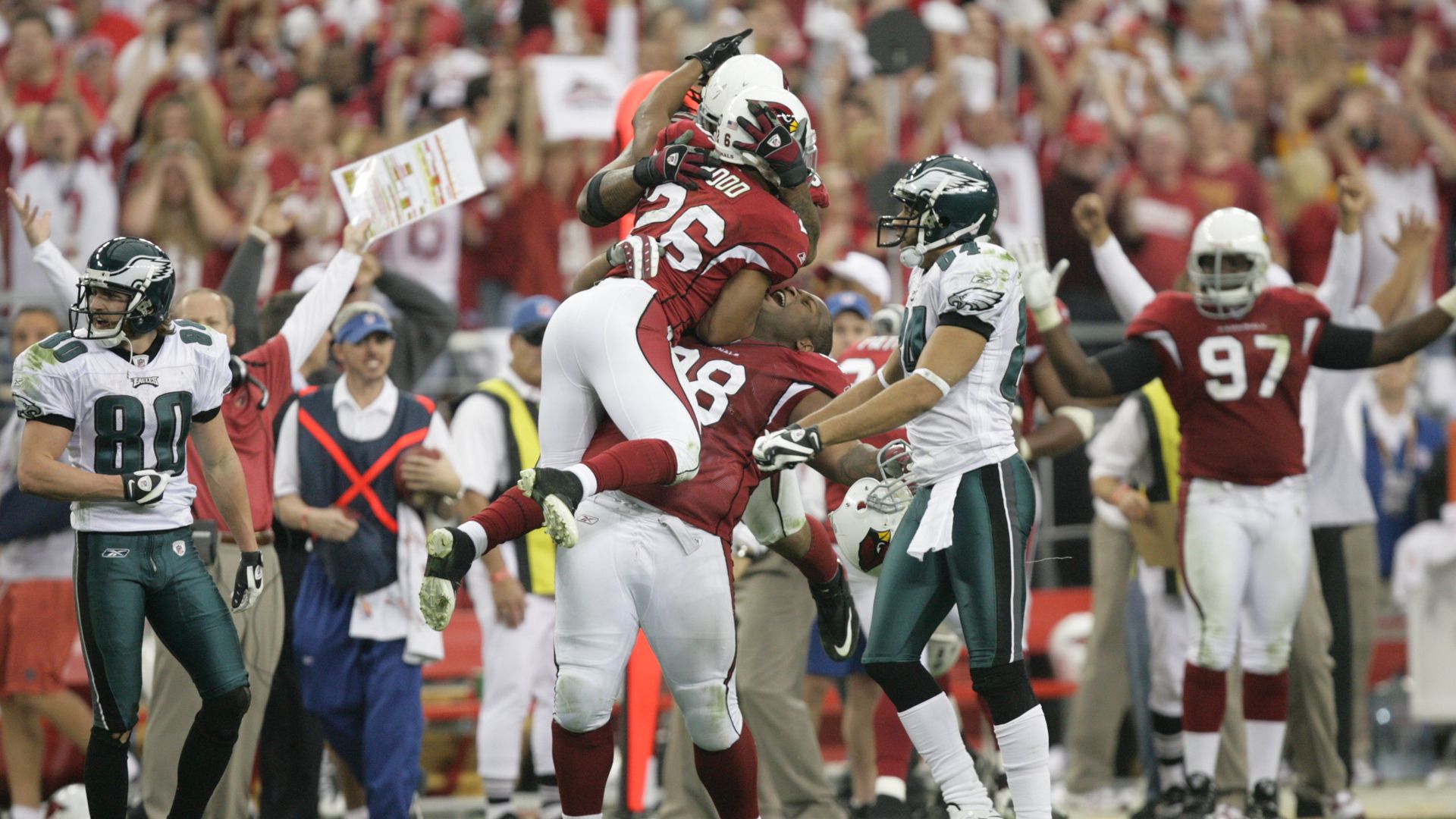 An Arizona Cardinals player jumps into a teammate's arms in celebration. 