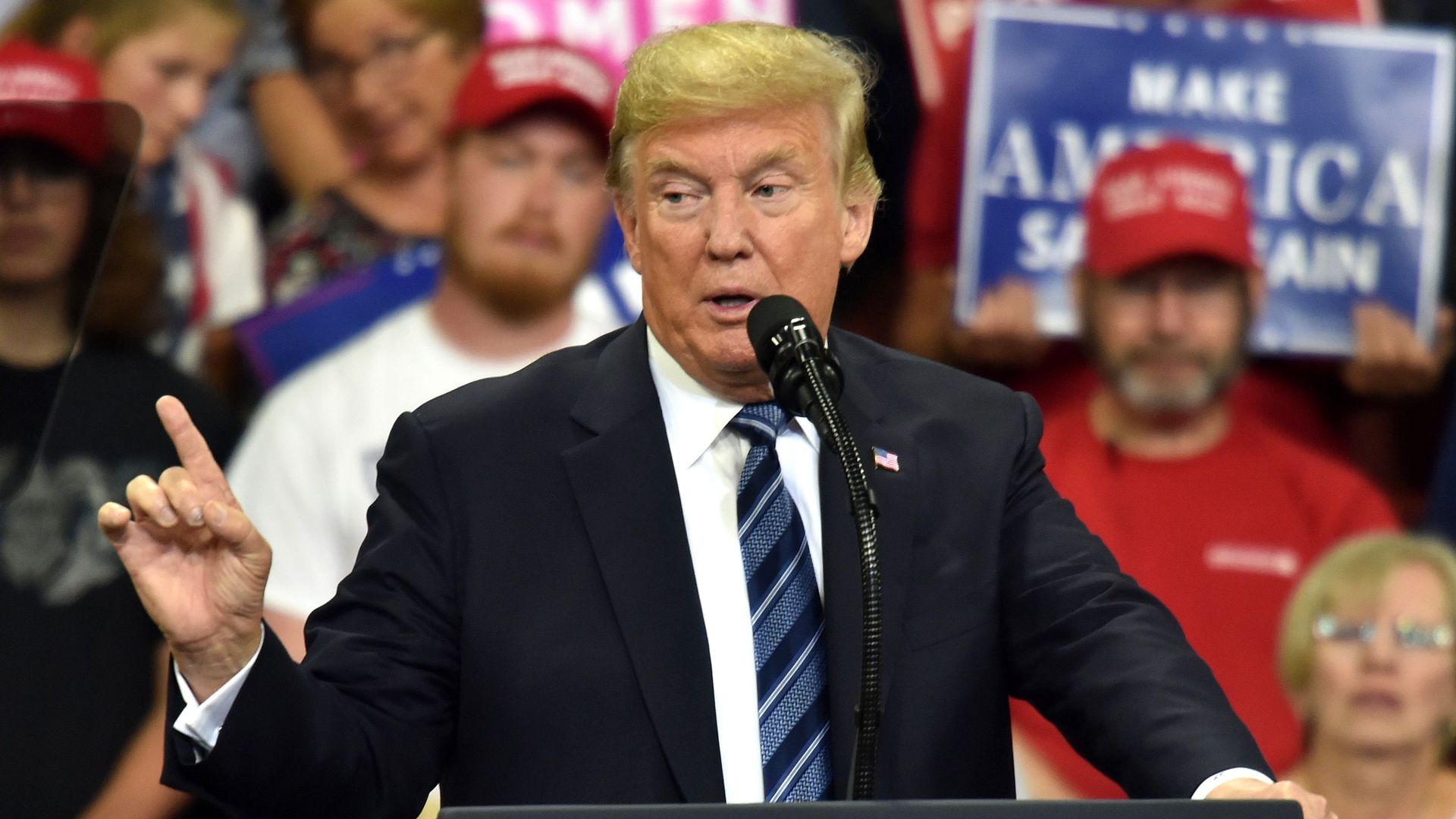 Trump lifts a finger while making a point onstage at a rally 