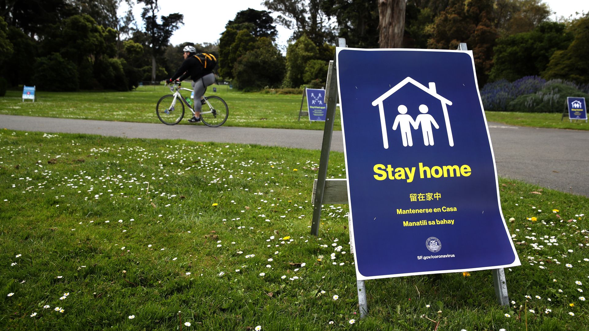 Photo of a standing sign that says "Stay home" sitting on green grass