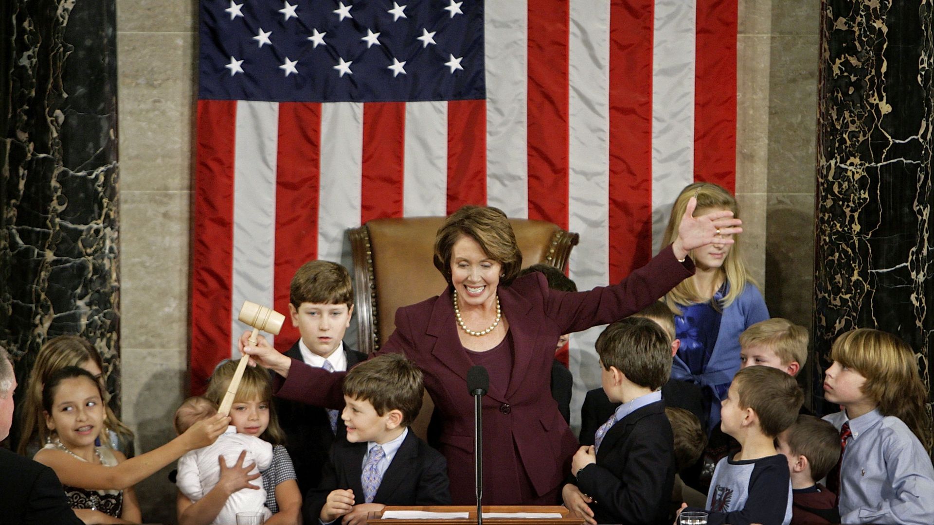 Nancy Pelosi smiles as children gather around the rostrum to touch the gavel after her swearing-in as the first female House speaker in 2007.