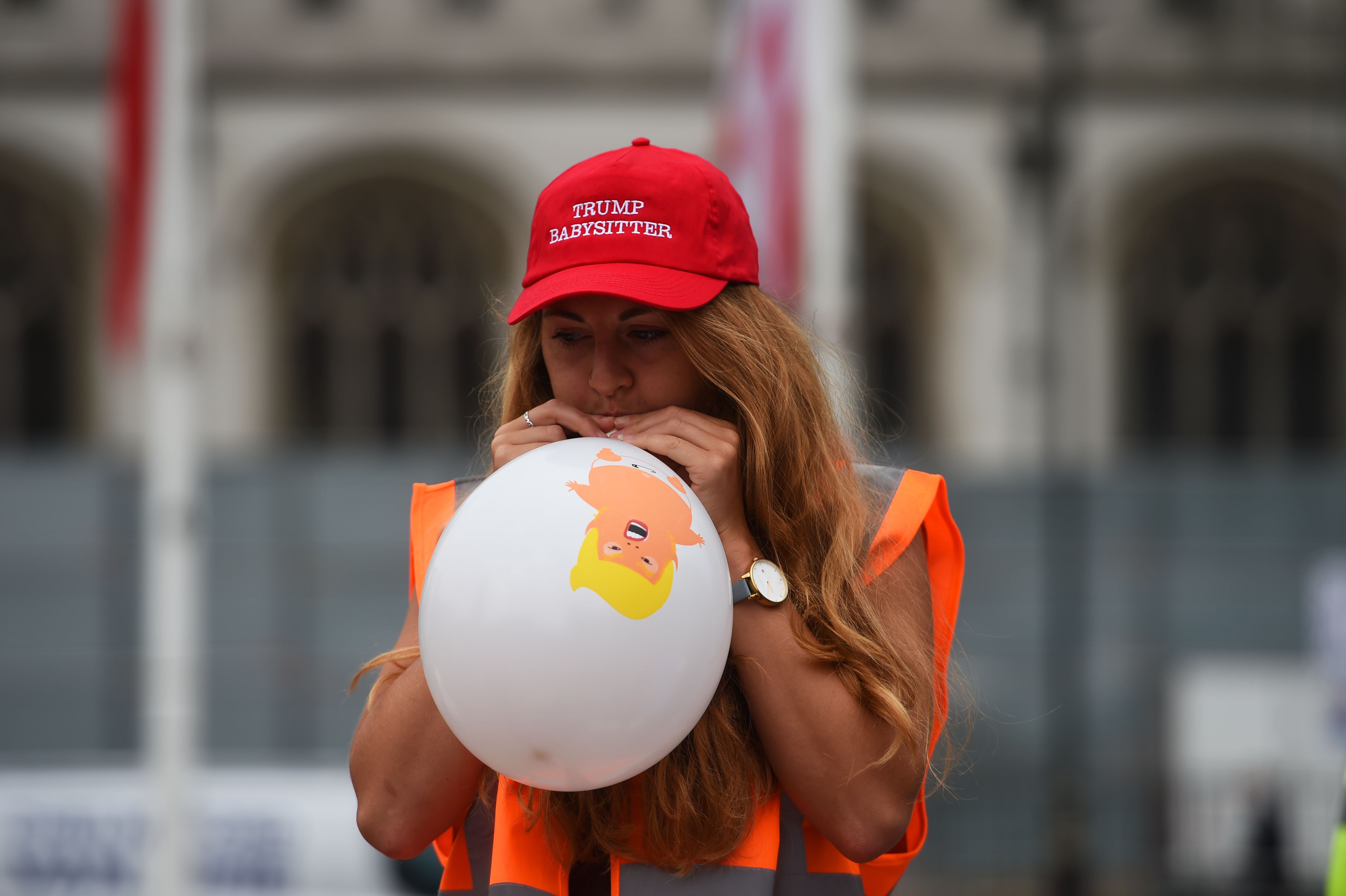 A member of the Baby Trump Balloon team blows up a balloon in Parliament Square, London.