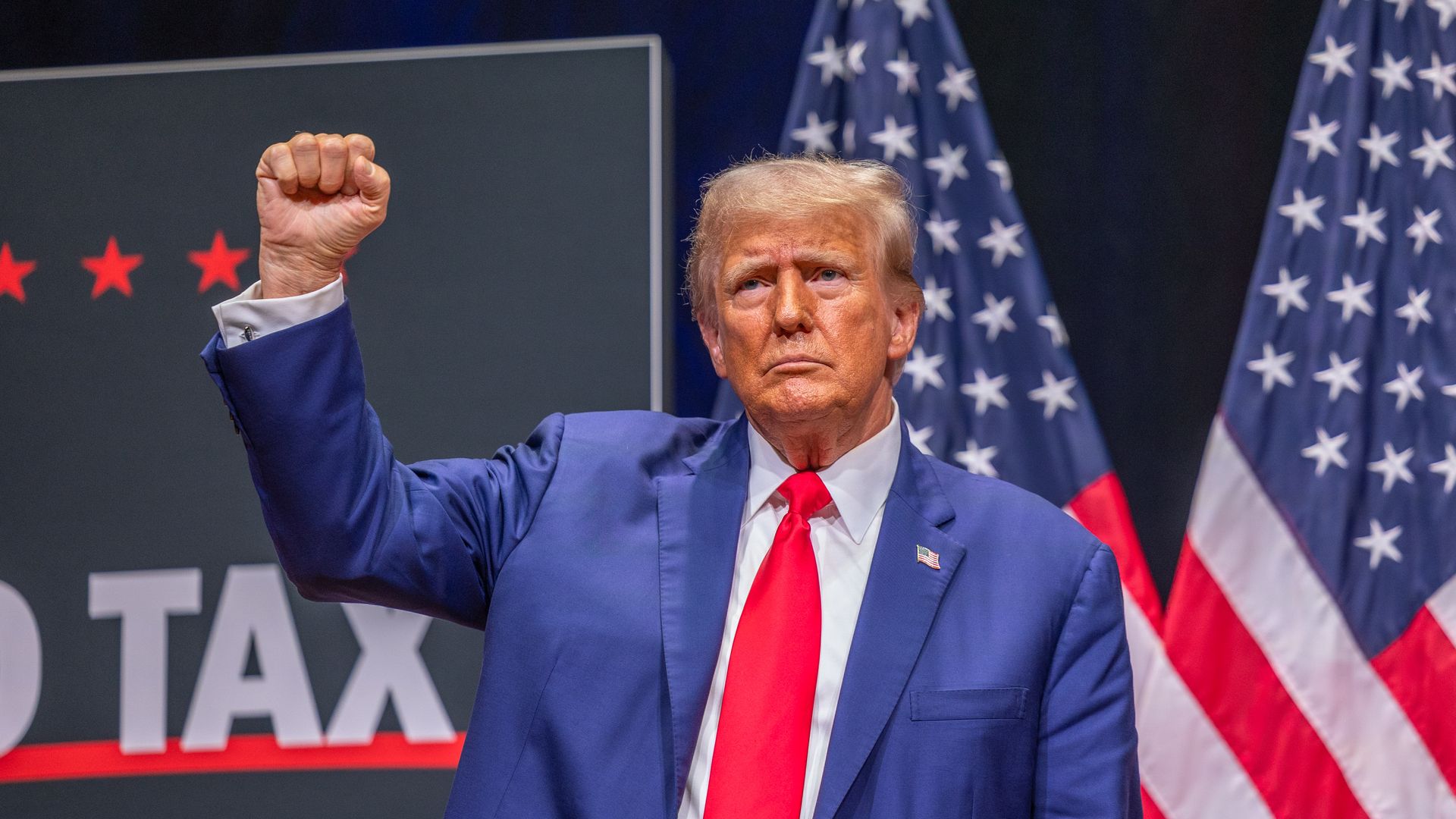 Former President Trump raises his fist at a campaign stop.