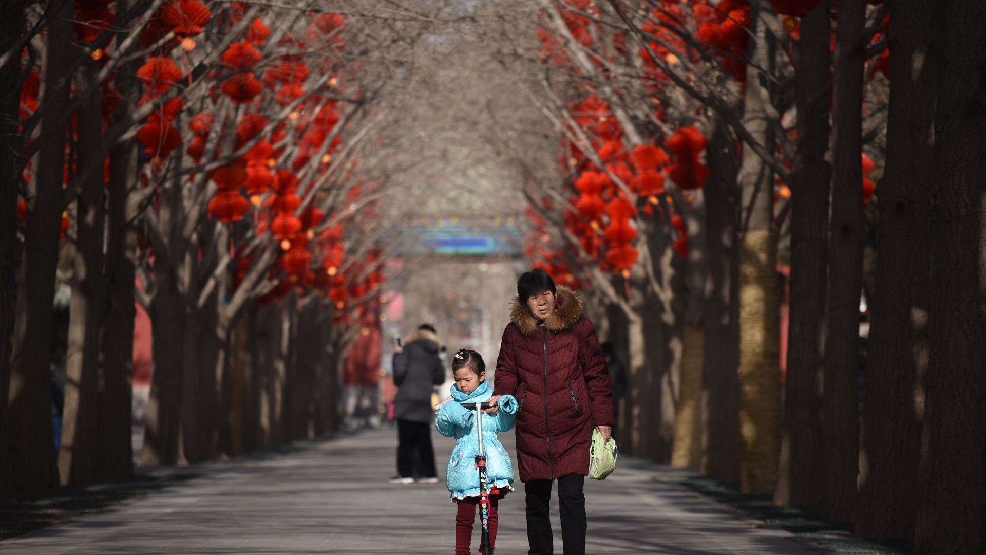 Older woman walking with young child in Beijing park