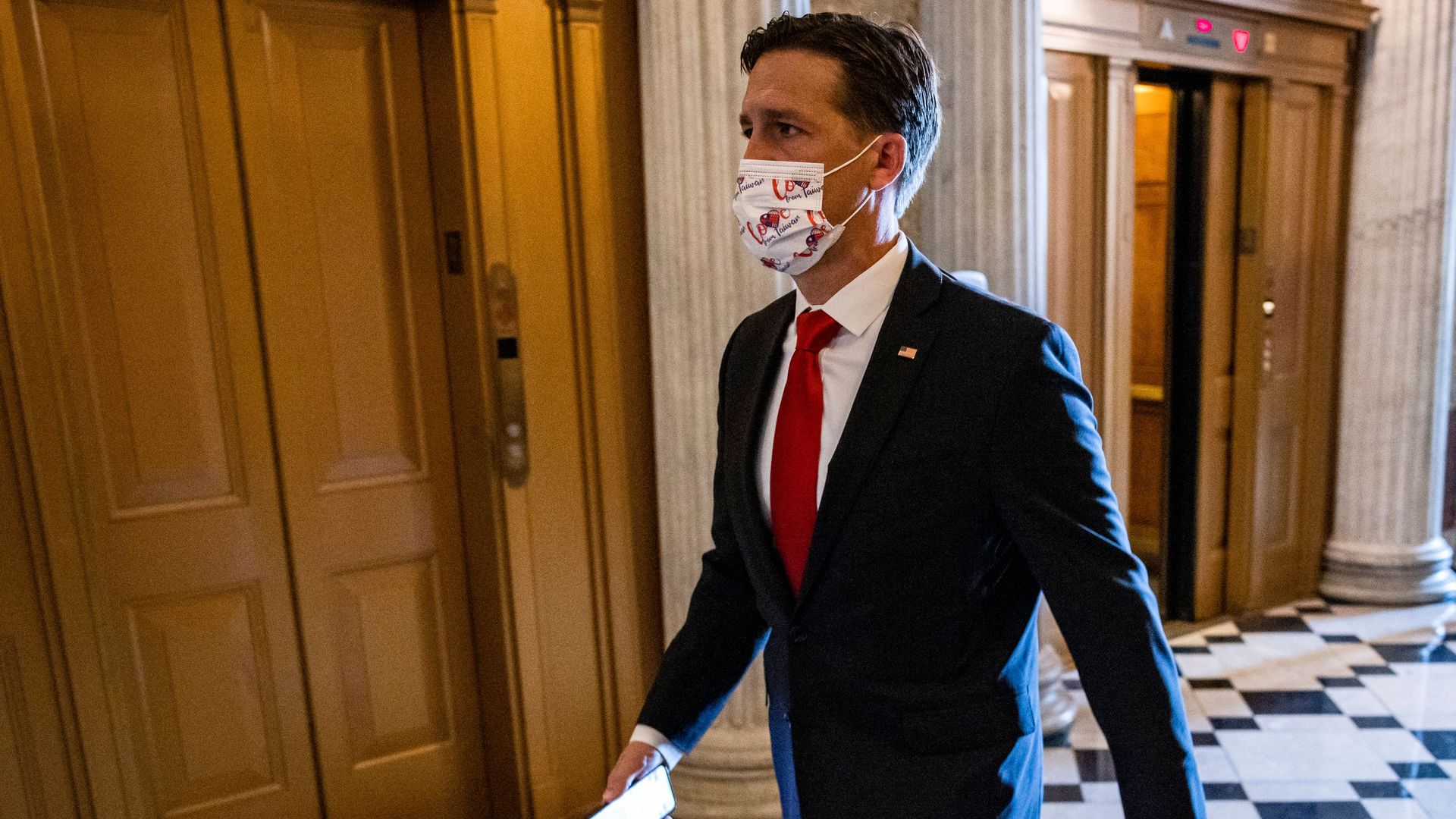 Photo of a masked Ben Sasse walking in the halls