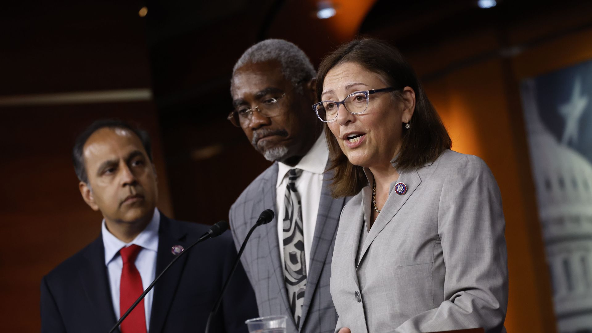 Rep. Suzan DelBene, wearing a gray suit and glasses, speaks at a press conference at the Capitol.
