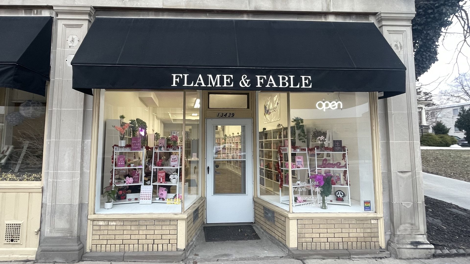 Storefront of a bookstore called "Flame & Fable" with black awning