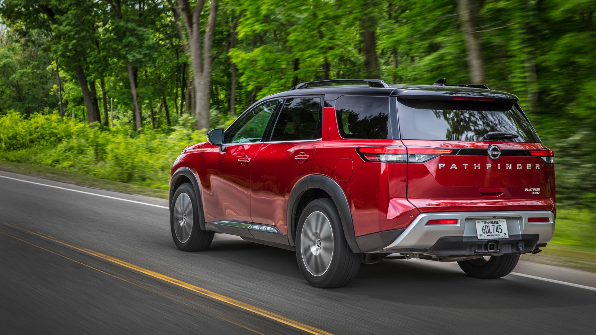 Image of red 2022 Nissan Pathfinder SUV on a country road