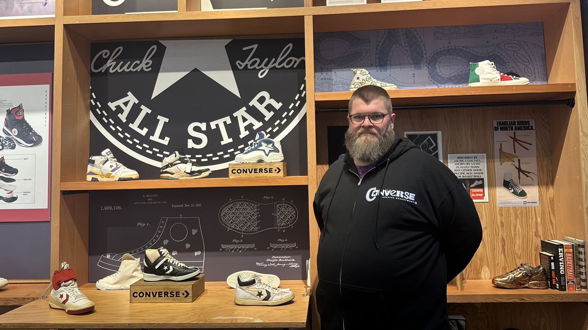 Sam Smallidge, Converse's archive manager, stands in front of historic Converse sneakers, including denim sneakers Converse made for the Kentucky Wildcase for their 1996 season.