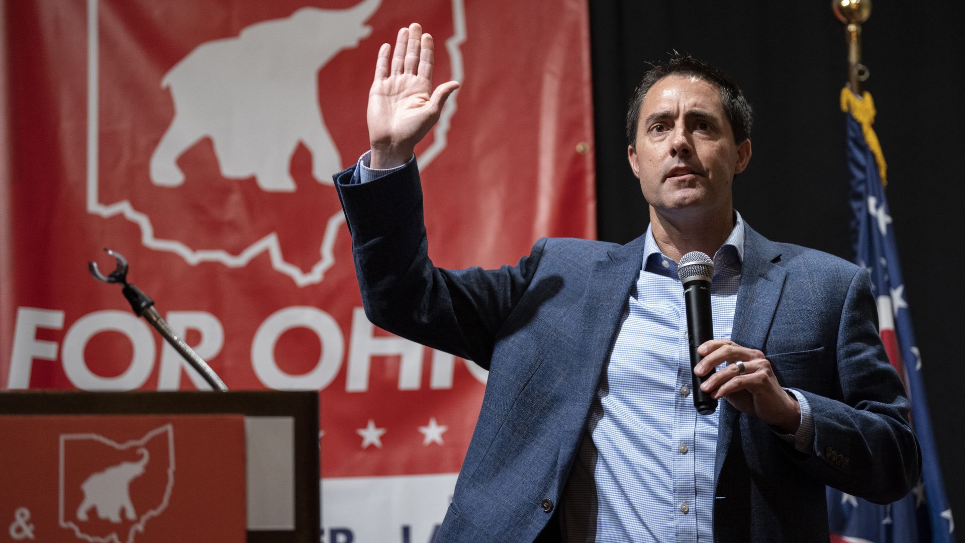 Ohio Secretary of State Frank LaRose holds his hand up while giving a speech.
