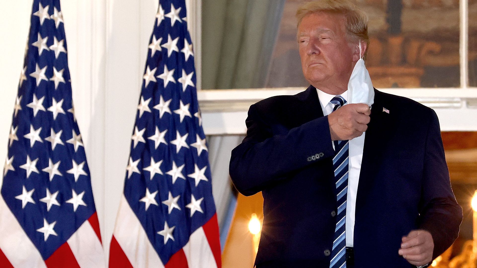 President Donald Trump removes his mask upon return to the White House from Walter Reed National Military Medical Center on October 05, 2020 in Washington, DC. 