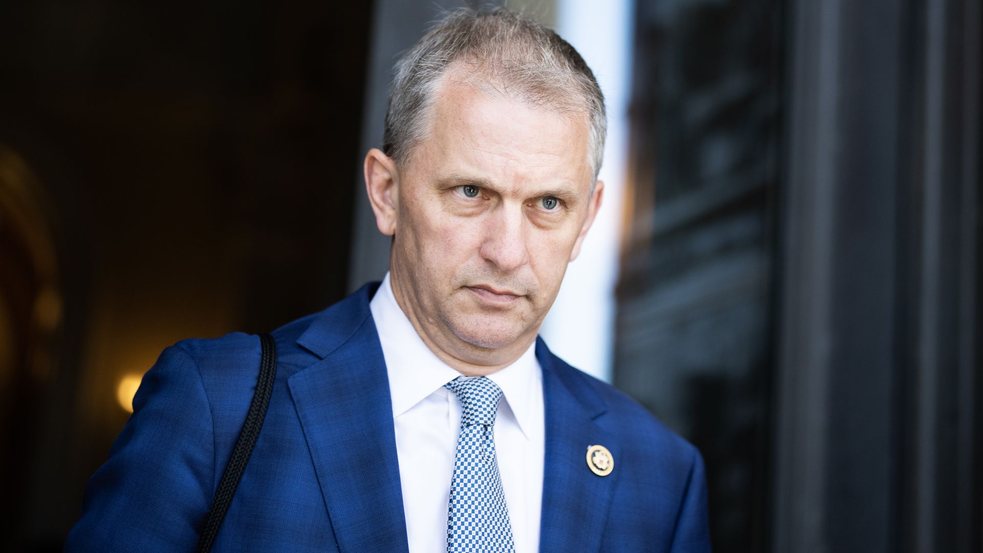 Photo of a man in a suit leaving a building