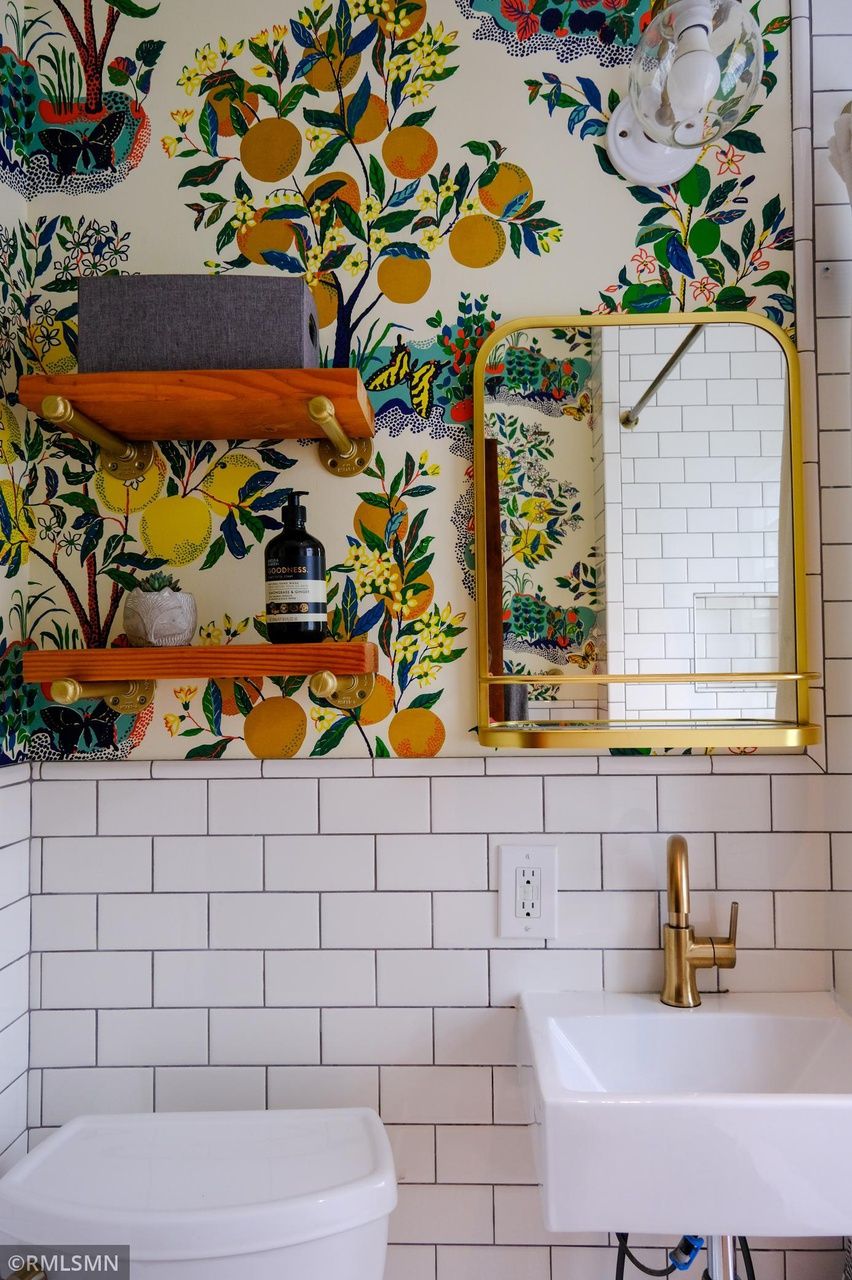bathroom with wallpaper that has citrus fruit pattern