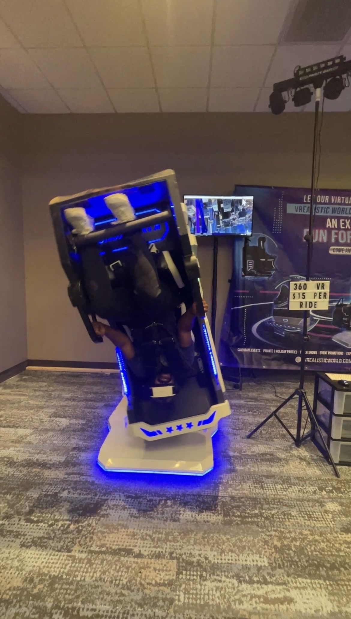 Axios's Wil Nobles rides inside of a 360 virtual reality game system.