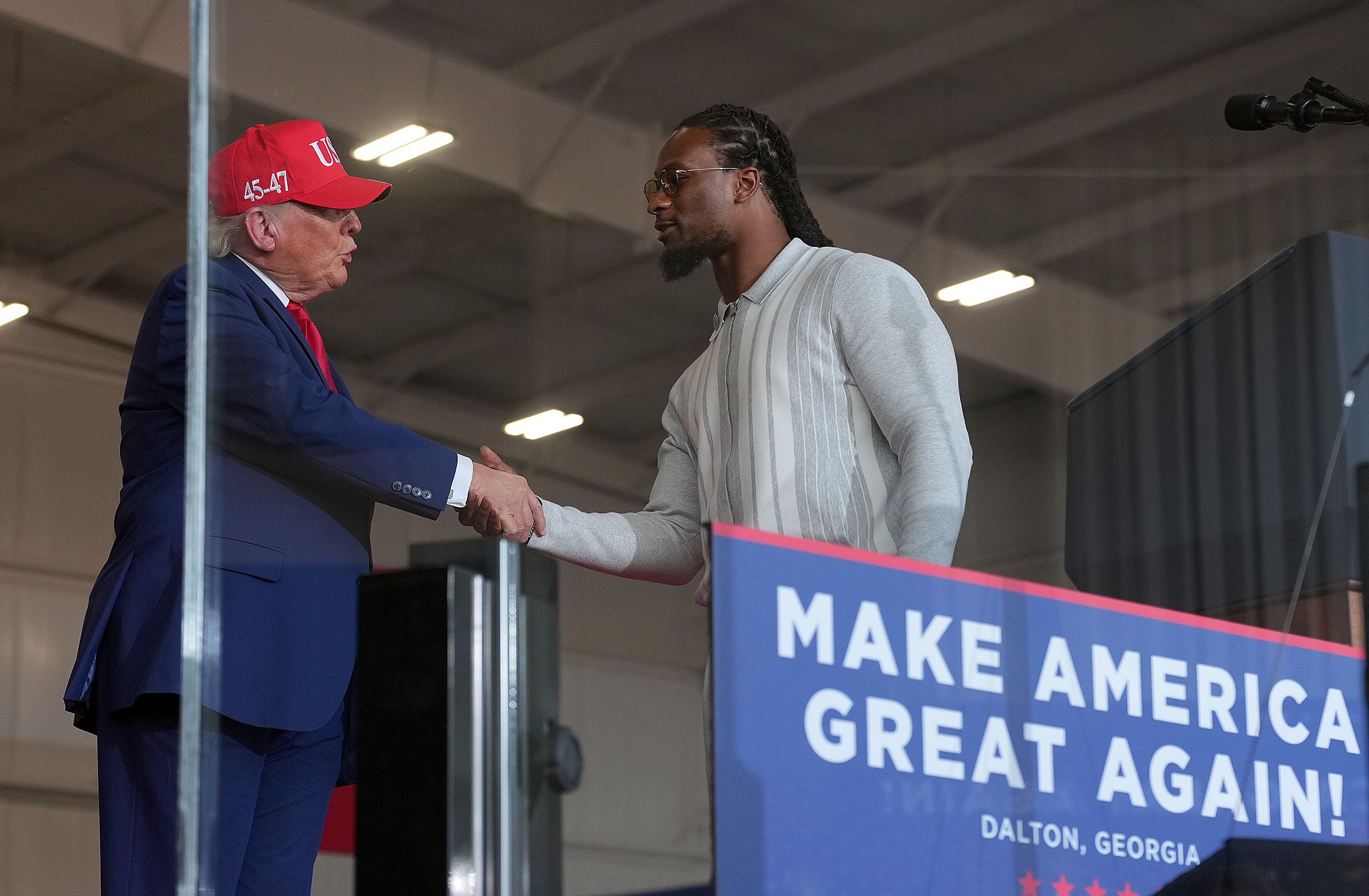 Donald Trump greets former NFL running back Todd Gurley at a campaign rally at Dalton Municipal Airport.