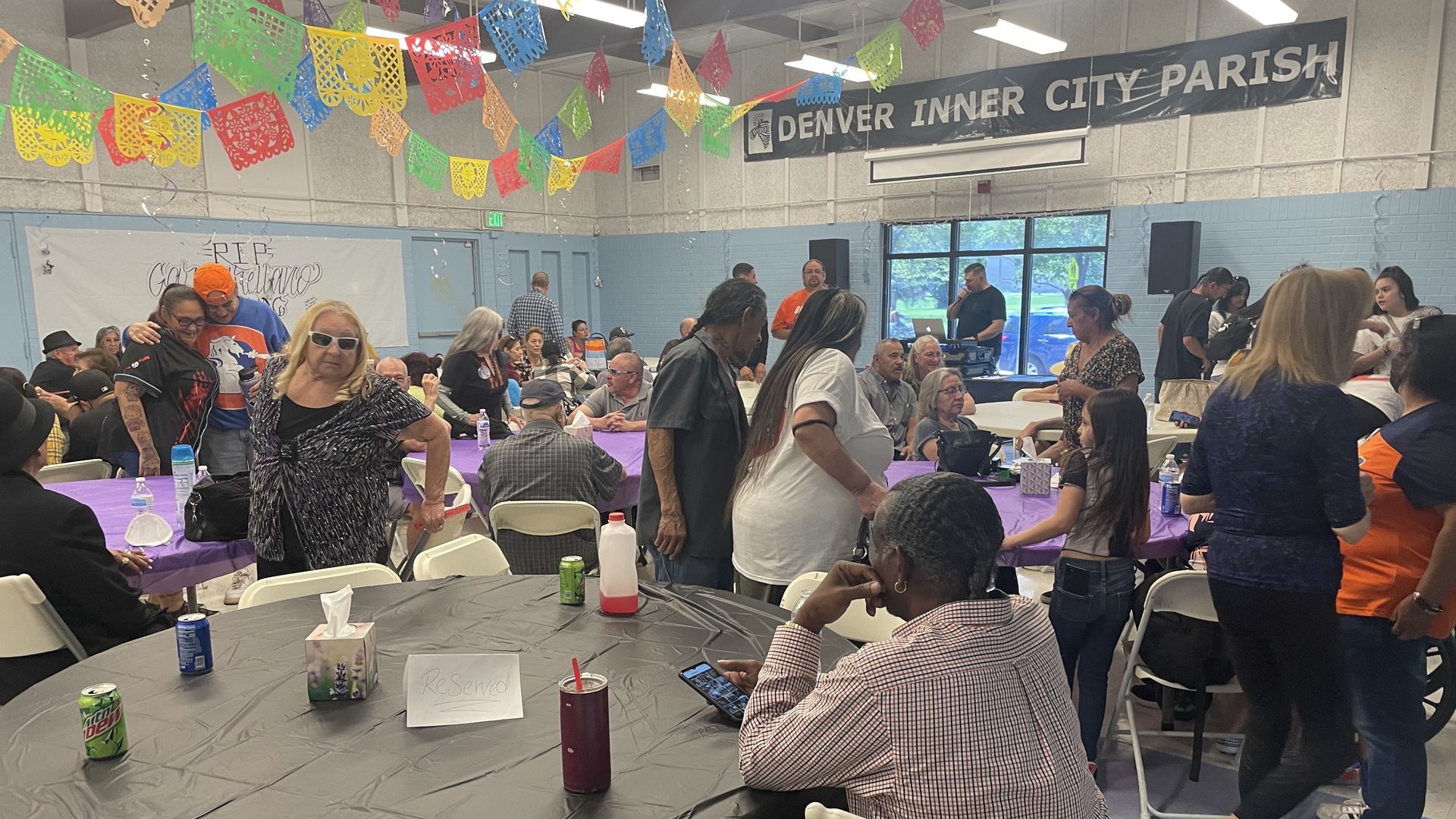 Several people attend a benefit inside the Denver Inner City Parish building in west Denver. 