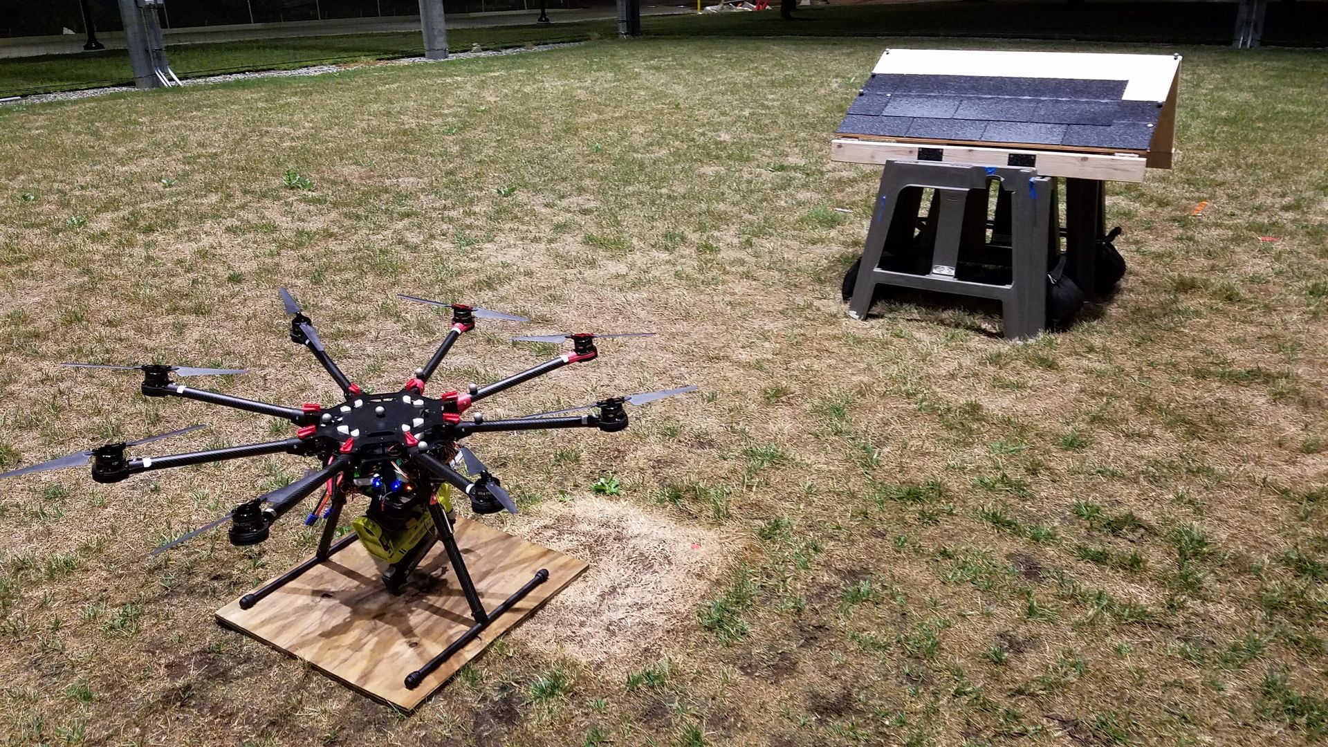 Image of a drone with a nail gun and a mock rooftop
