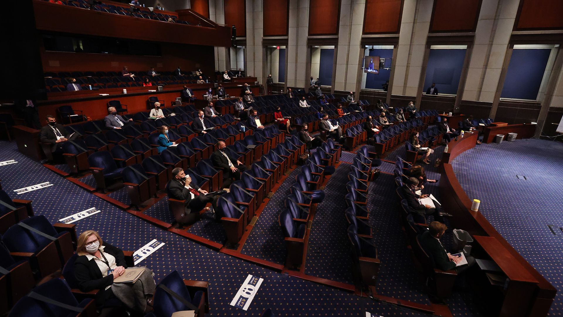 Photo of Congress members sitting socially distanced in an assembly wearing masks