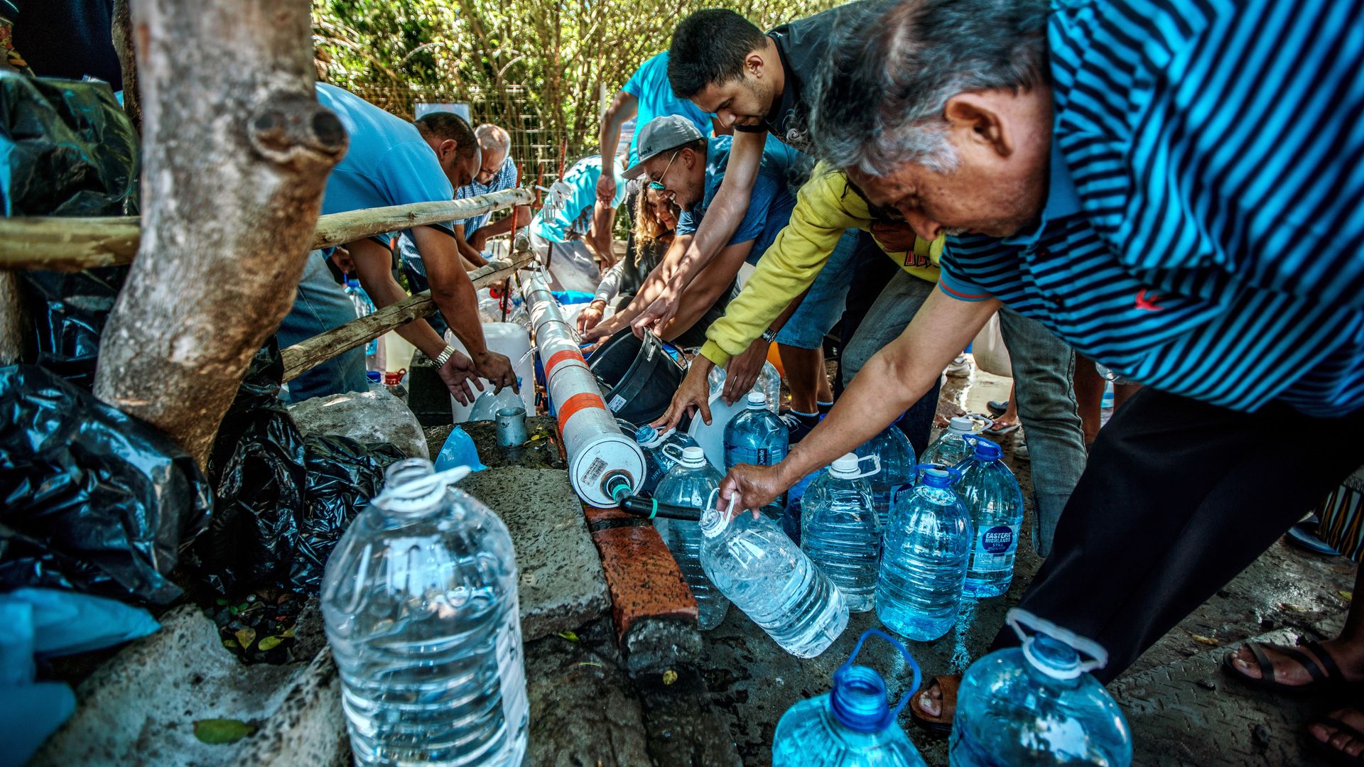 Cape Town residents filling water jugs from pipe