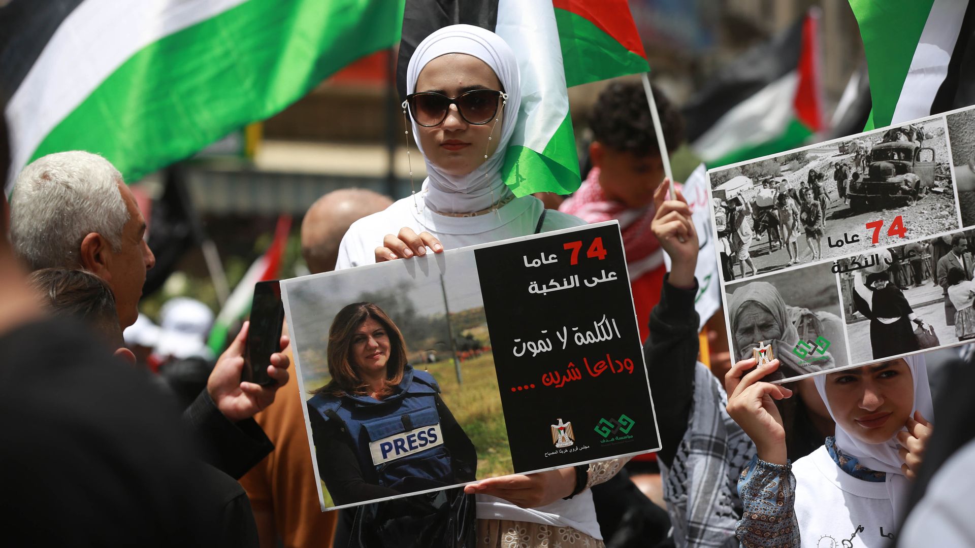 A Palestinian woman marking Nakba Day holds of poster of Palestinian American journalist Shireen Abu Akleh. Photo: 