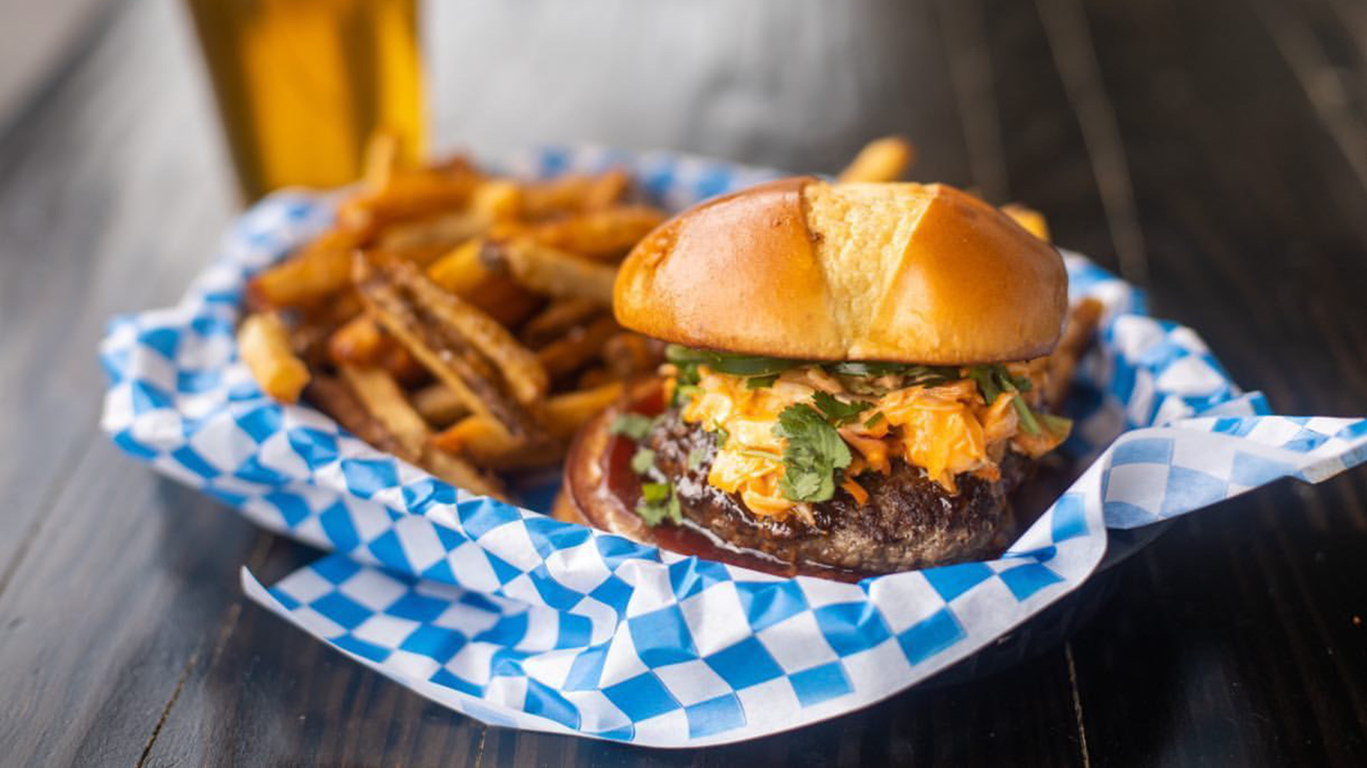 juicy lucy burger with extra cheese in a basket with fries