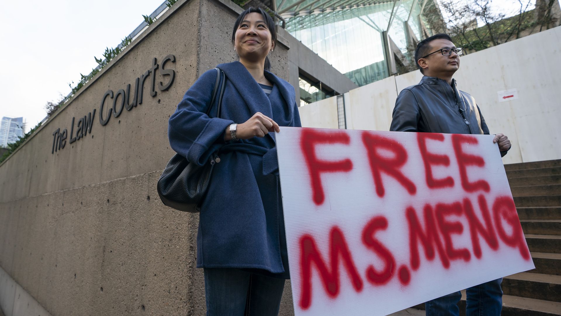 Protesters carrying sign reading "Free Ms. Meng" outside courthouse