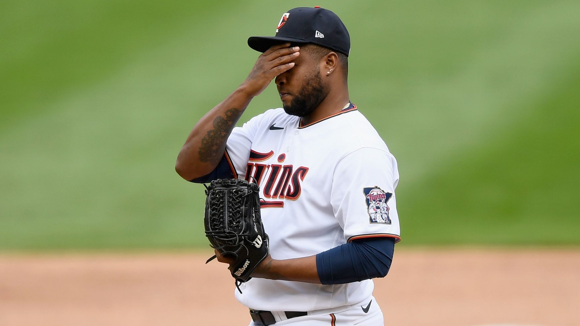 A baseball player puts his hand over his face