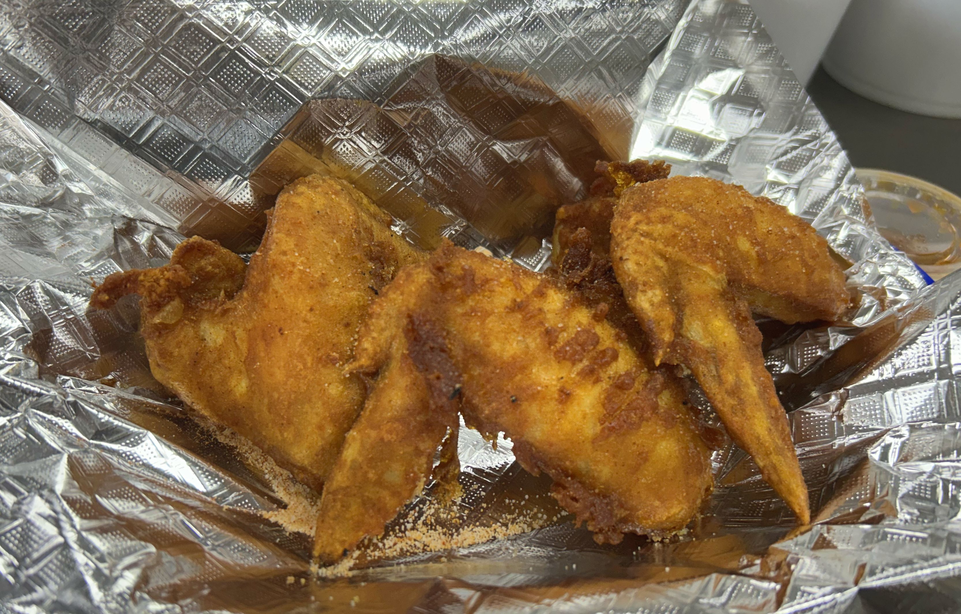 Chicken Wings from Kelly's Cambodian BBQ in an aluminum foil package. 