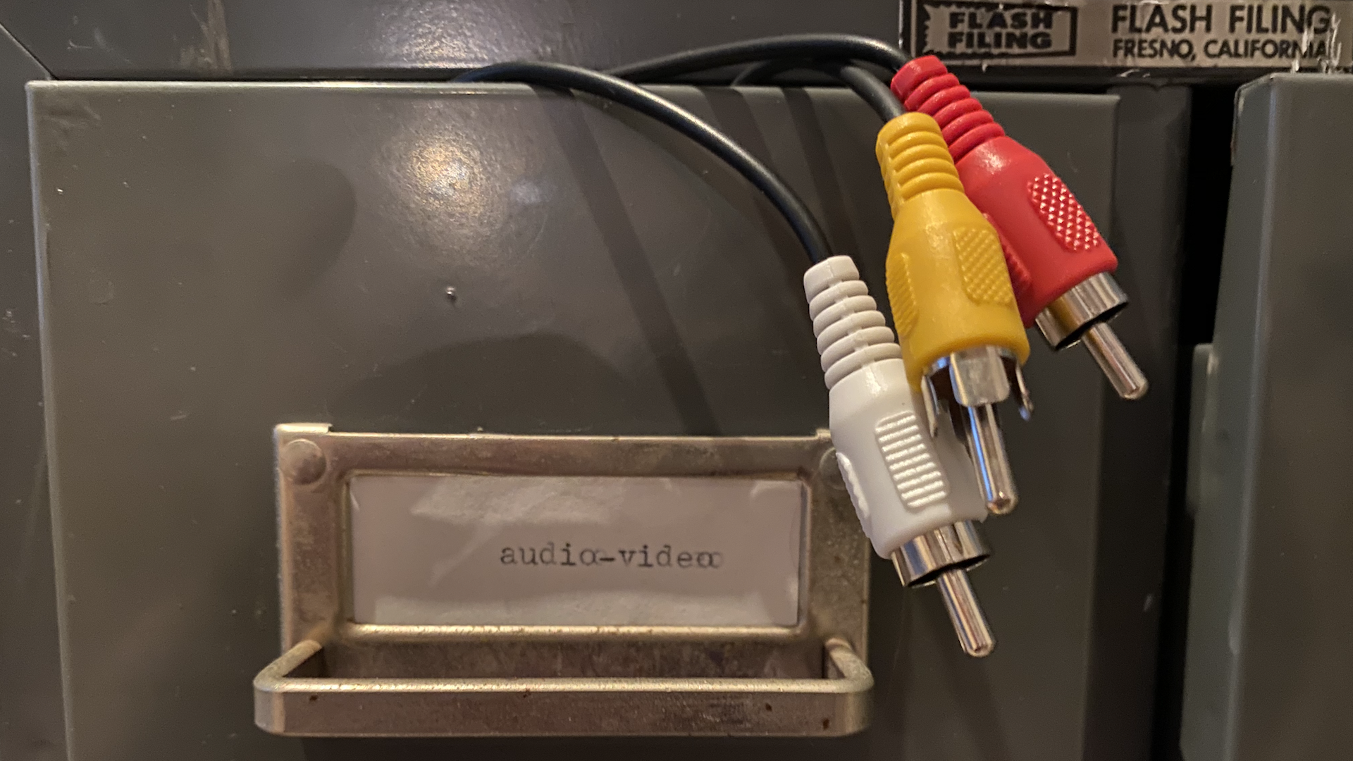 A "cord catalog" made up of an old card catalog with computer cords, including one labeled "audio/visual"