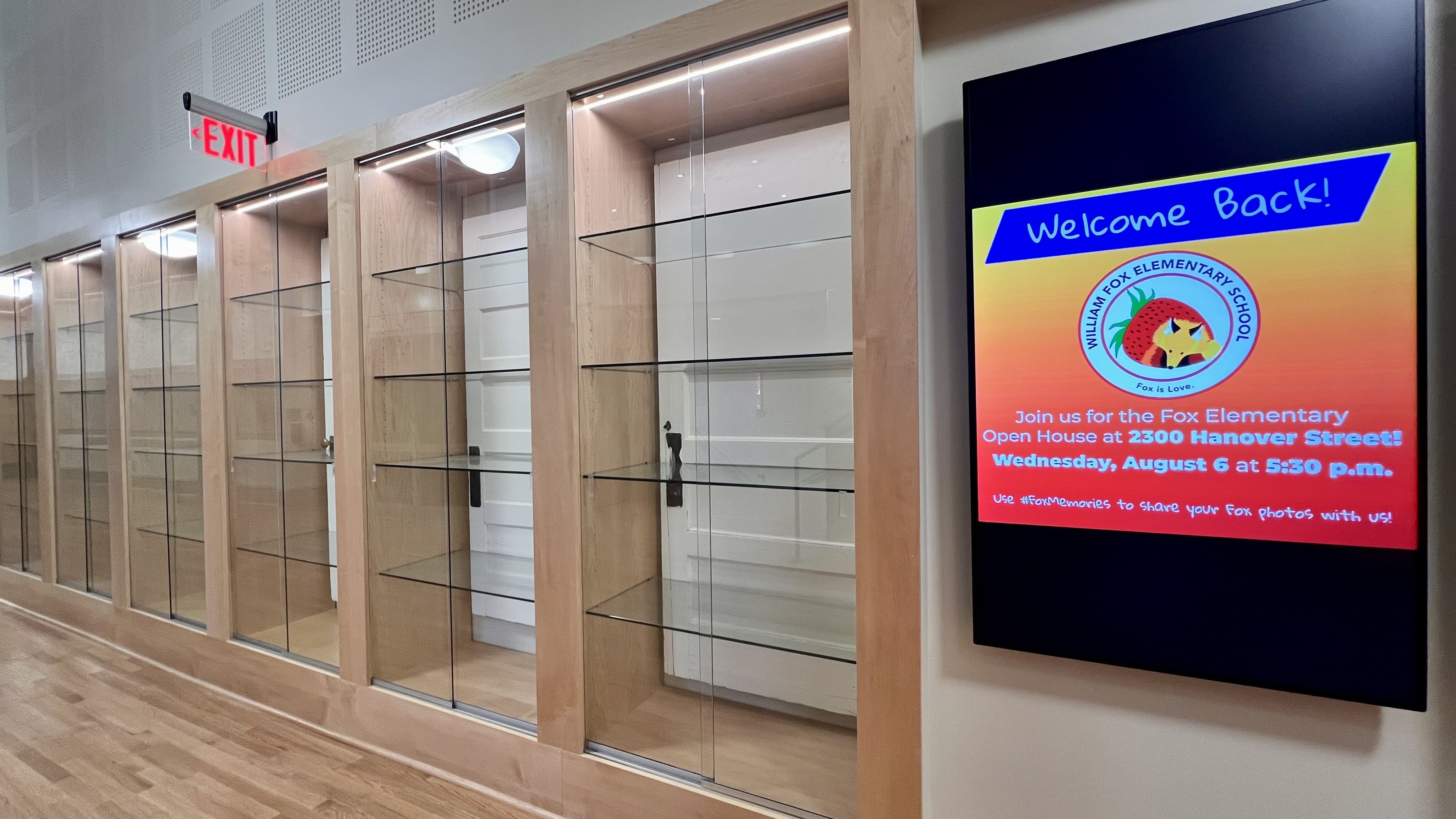a trophy case with doors in the back of the case and a "Welcome back" sign to the right