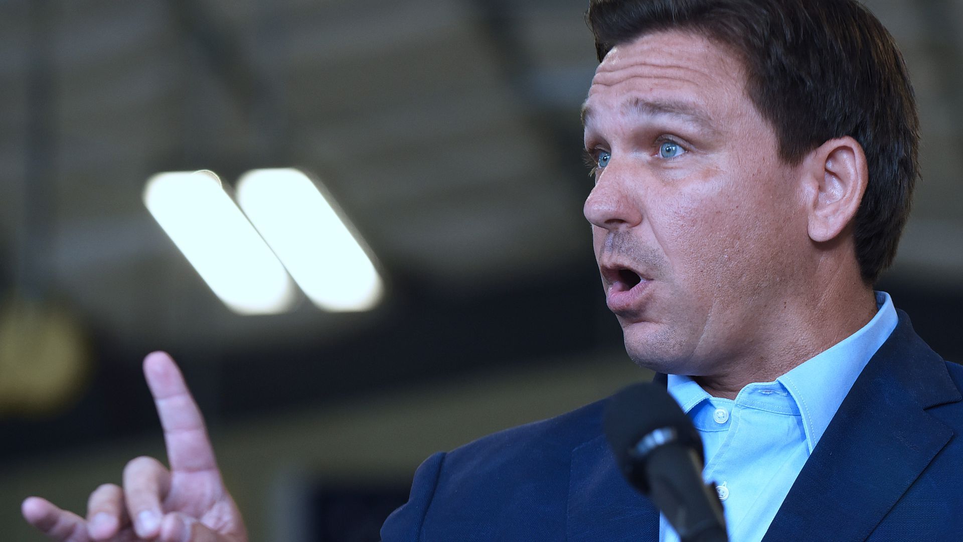 Photo of Ron DeSantis' side profile as he speaks with one hand raised