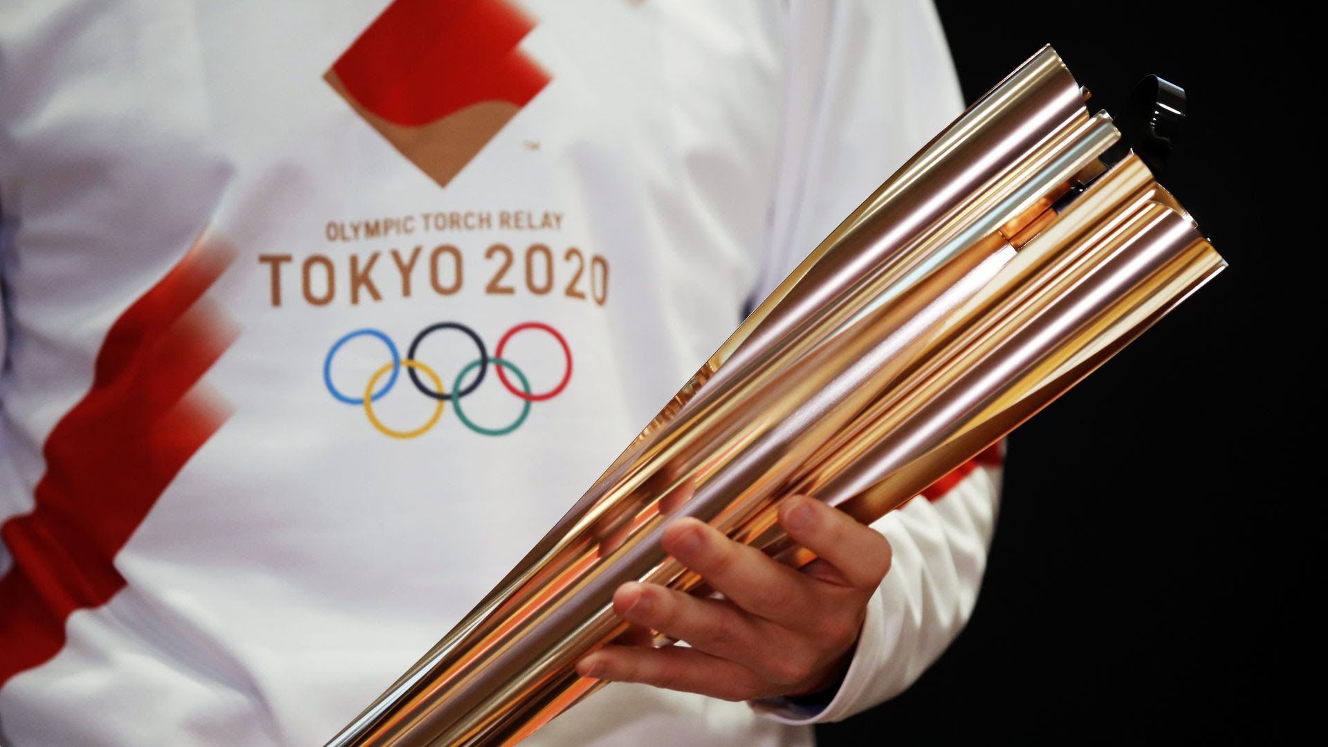 Greek singer Sakis Rouvas holds the torch of the Tokyo Olympic Games during a 2020 presentation of the torch relay in Athens. Photo: Thanassis Stavrakis/AP