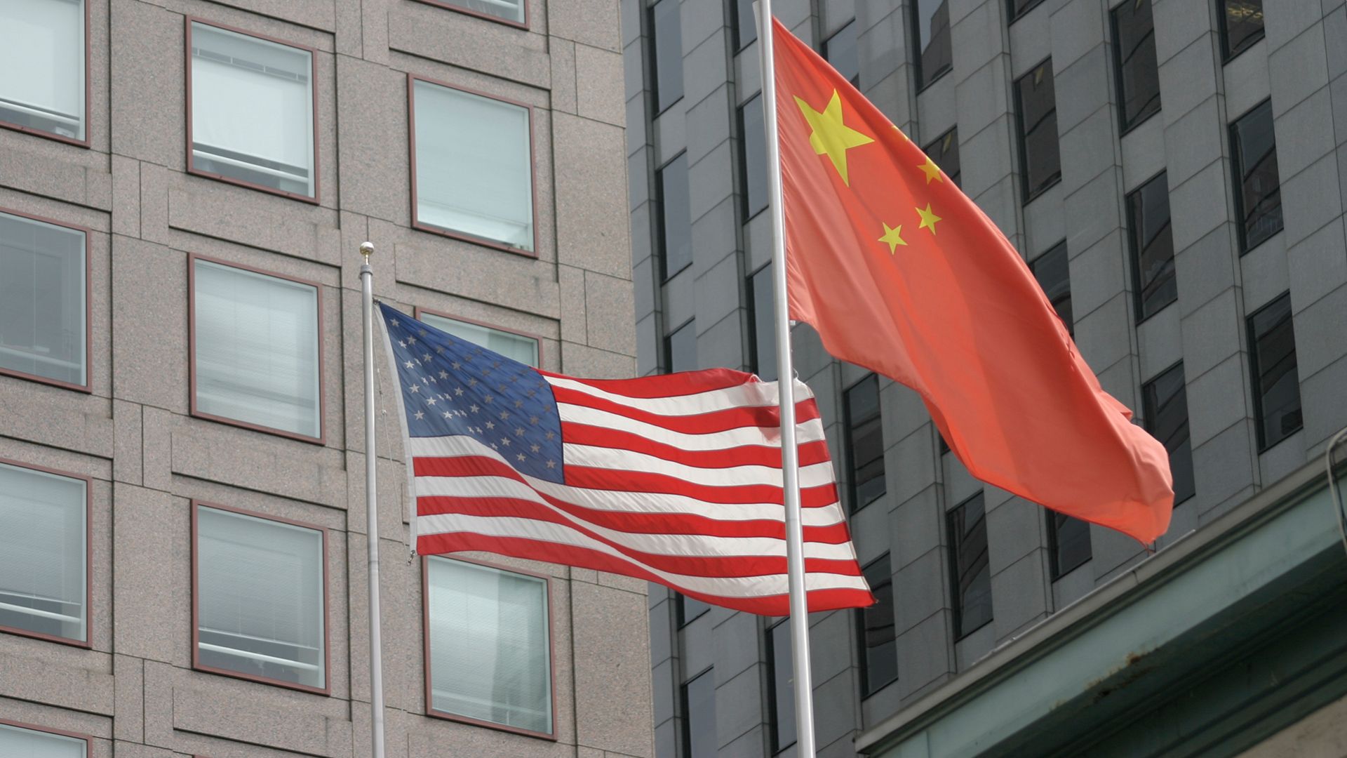 Chinese and American flags flying in front of buildings