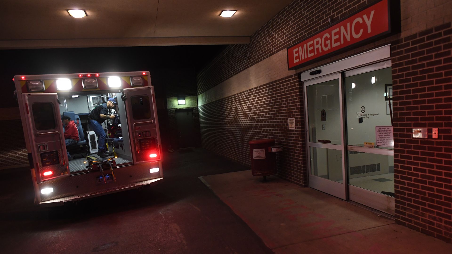 An ambulance is parked outside of a hospital emergency department.