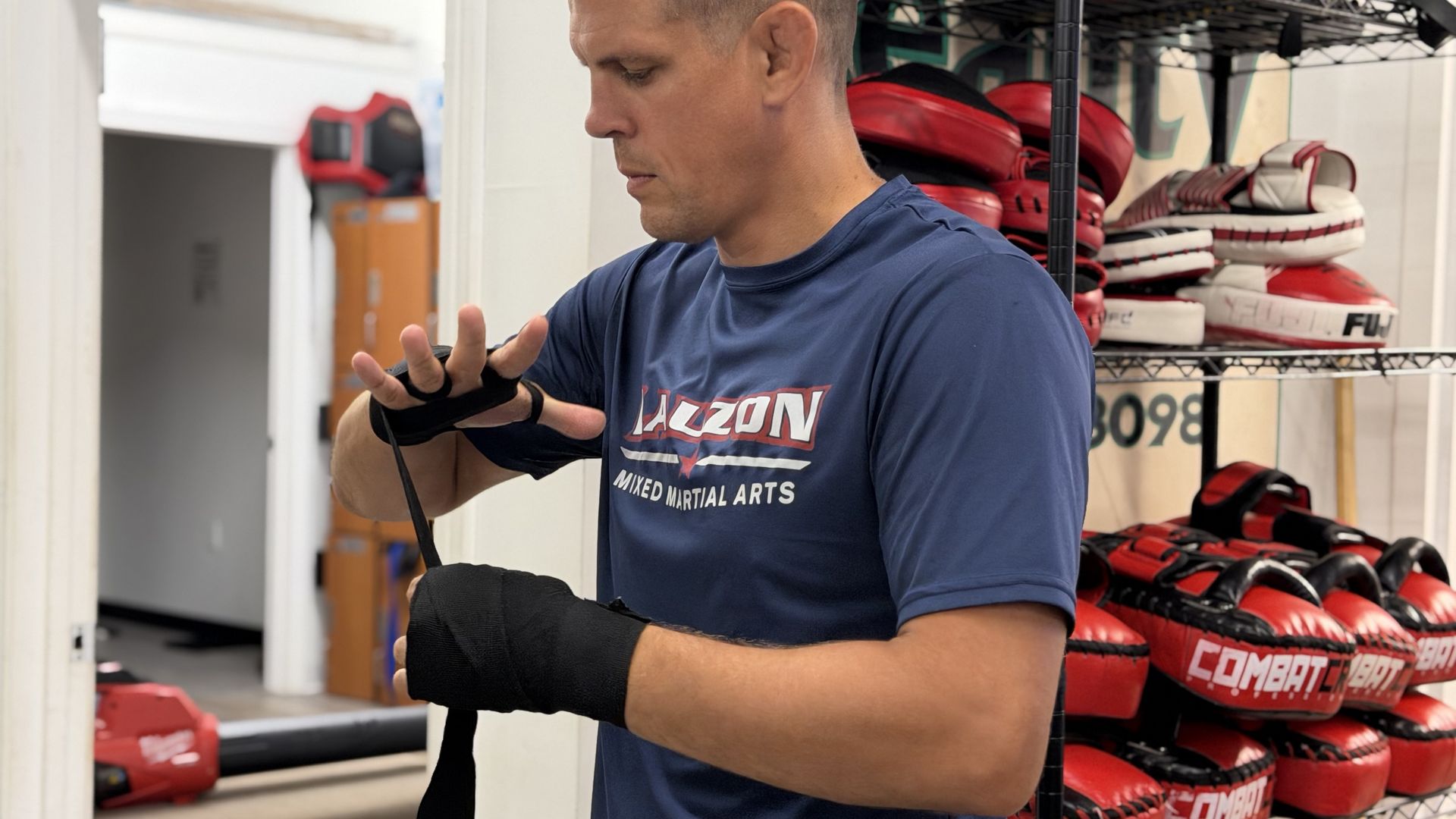 Former UFC fighter Joe Lauzon wraps his hands before practicing sparring at his gym in Raynham on Aug. 21, a week before his bare-knuckle fighting debut at Fenway Park.